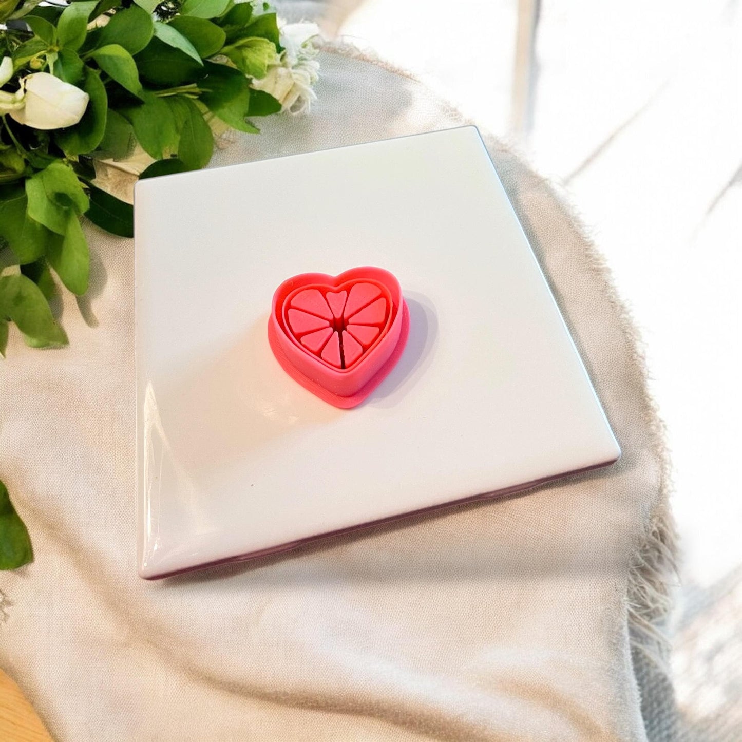 Top-down view of red cutter with heart citrus shape and inner embossed lines