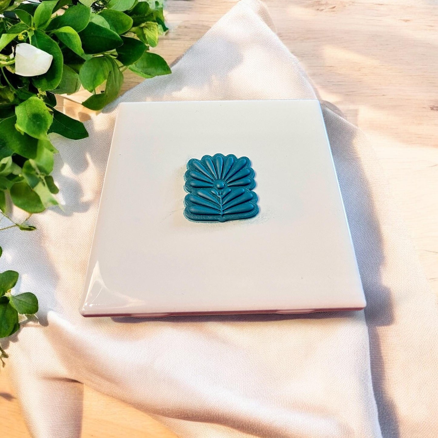 Finished folk flower clay piece shaped for dangles, showing clean lines and Scandinavian arch design