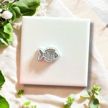 Gray whimsical fish clay cutter displayed on a white ceramic tile, ideal for coastal-inspired polymer clay jewelry.