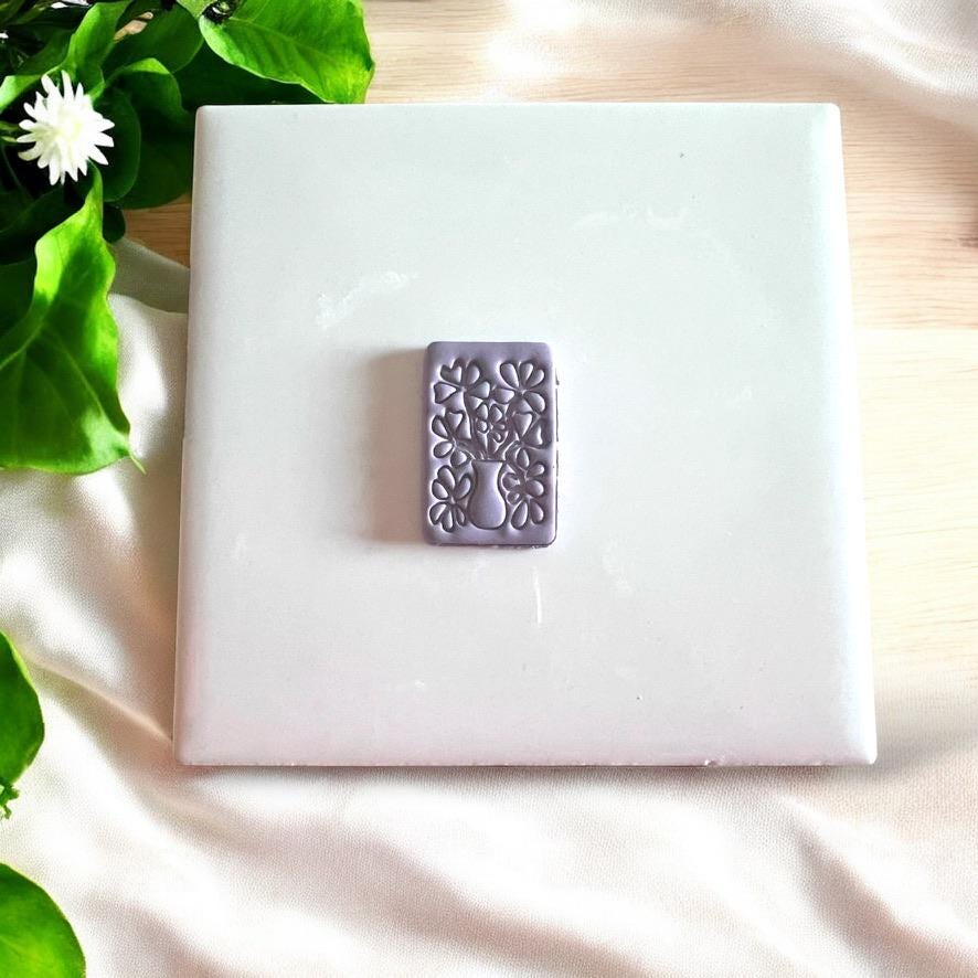 Purple clay impression of flower vase bouquet cutter, great for making polymer clay earrings.
