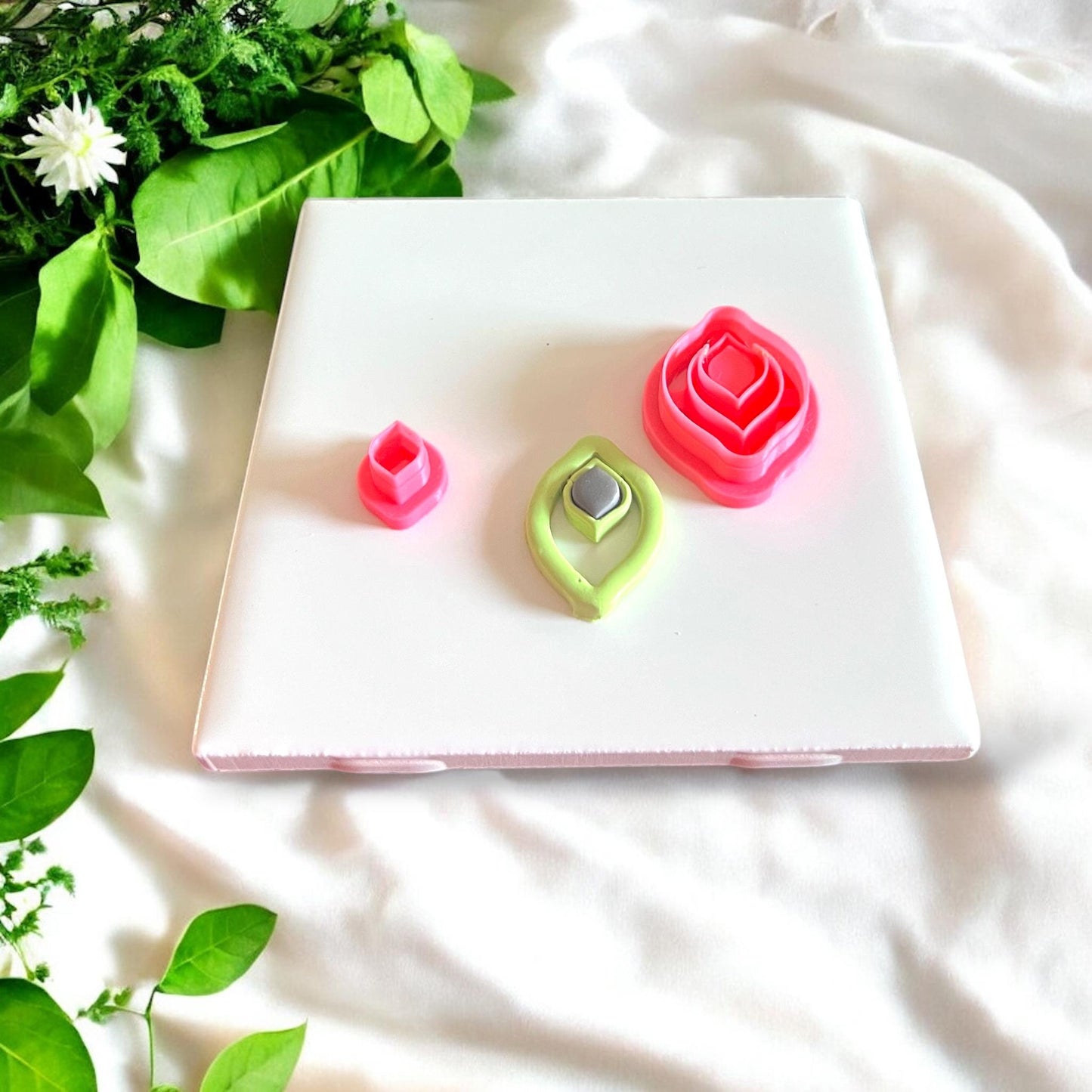Jewel drop cutters, green and gray clay cutouts, and full cutter set displayed for size comparison on white tile