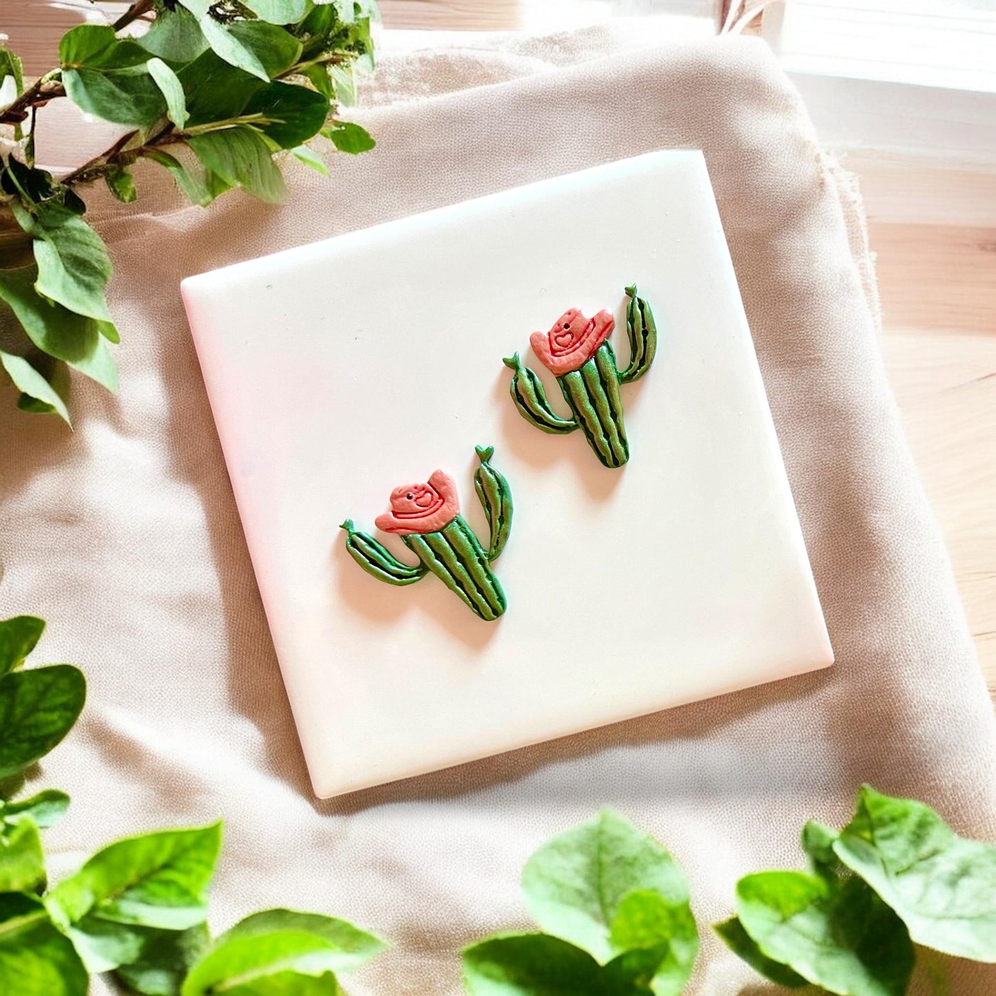 Completed earrings made from the cowboy cactus cutter in green and pink clay.