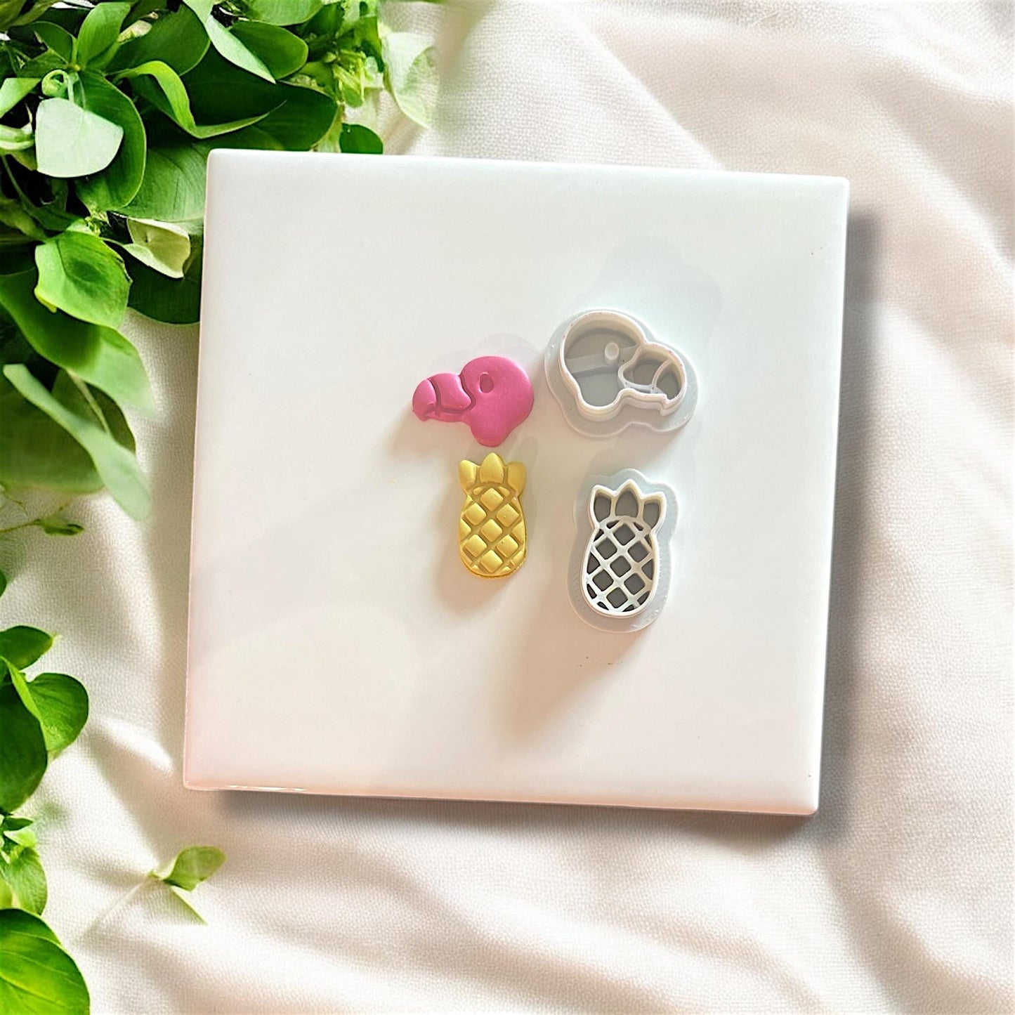 Flamingo and pineapple cutters in white on ceramic tile