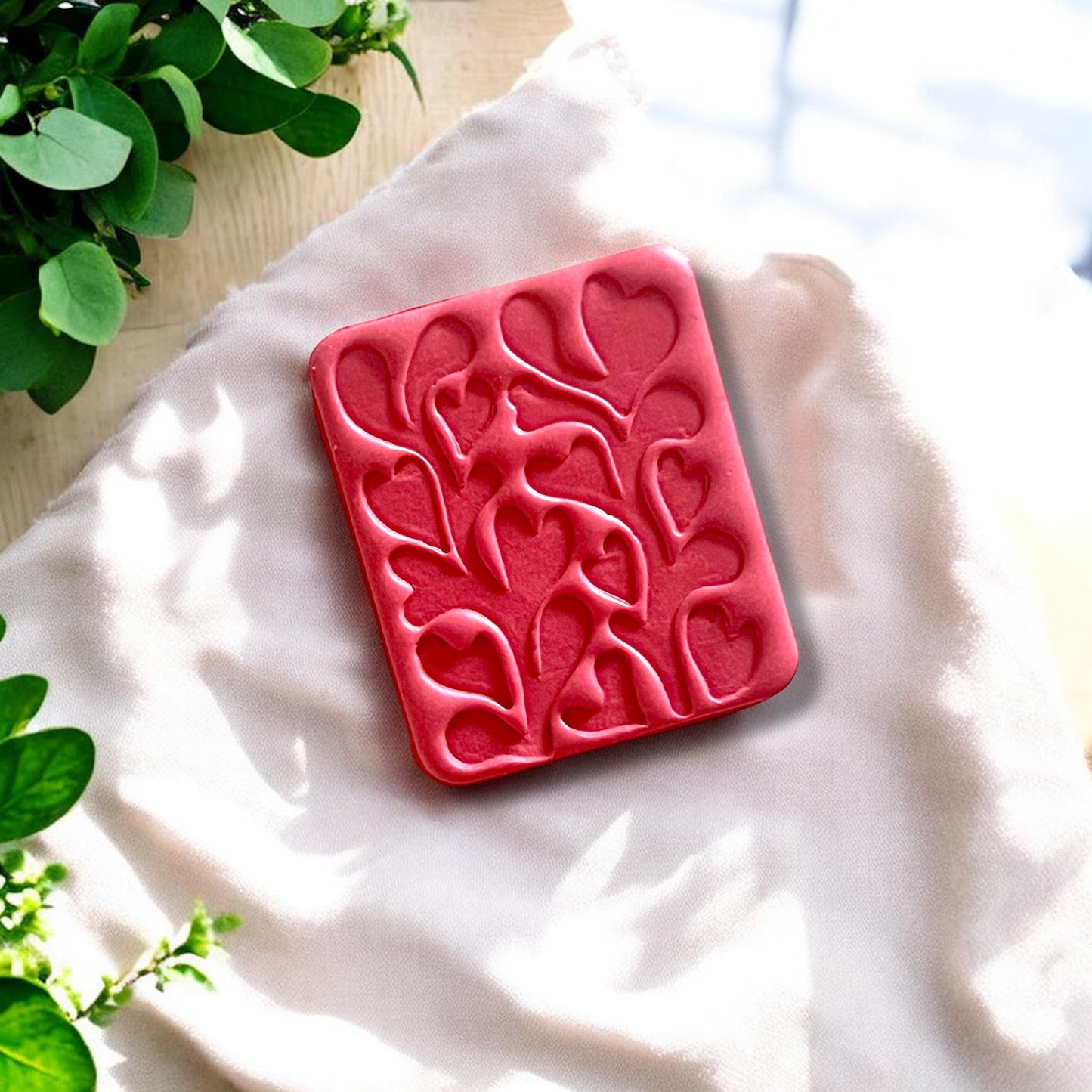 finished Matisse heart clay earrings on fabric