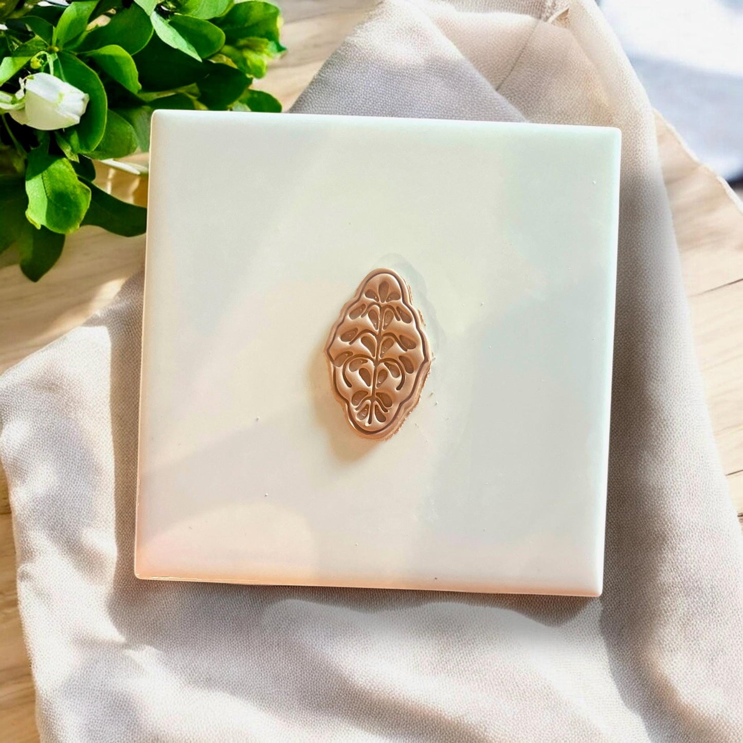 Brown polymer clay earring cutout with boho floral detailing