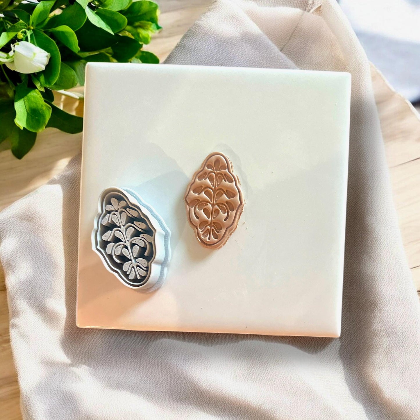 Debossed clay cutter and matching brown floral clay cutout shown together