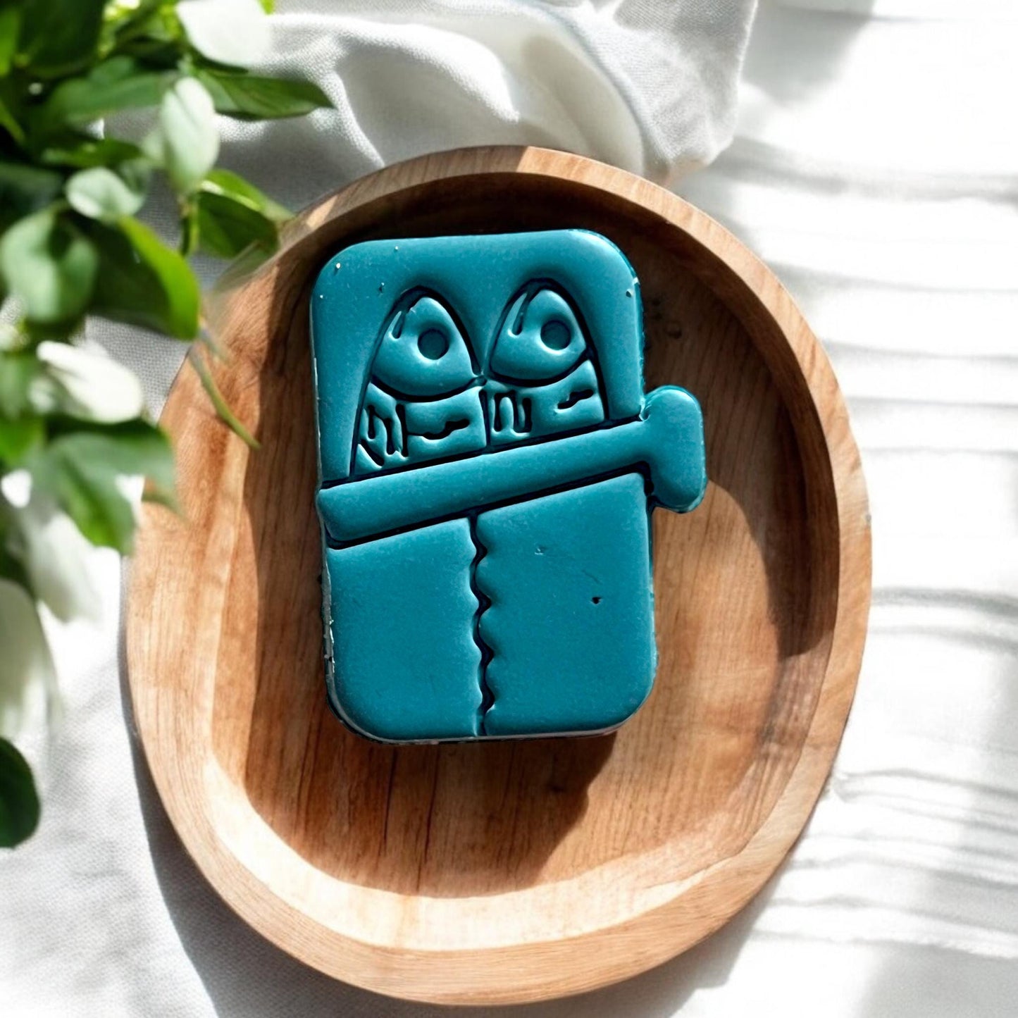Polymer clay cutter tool next to cut sardine can shape
