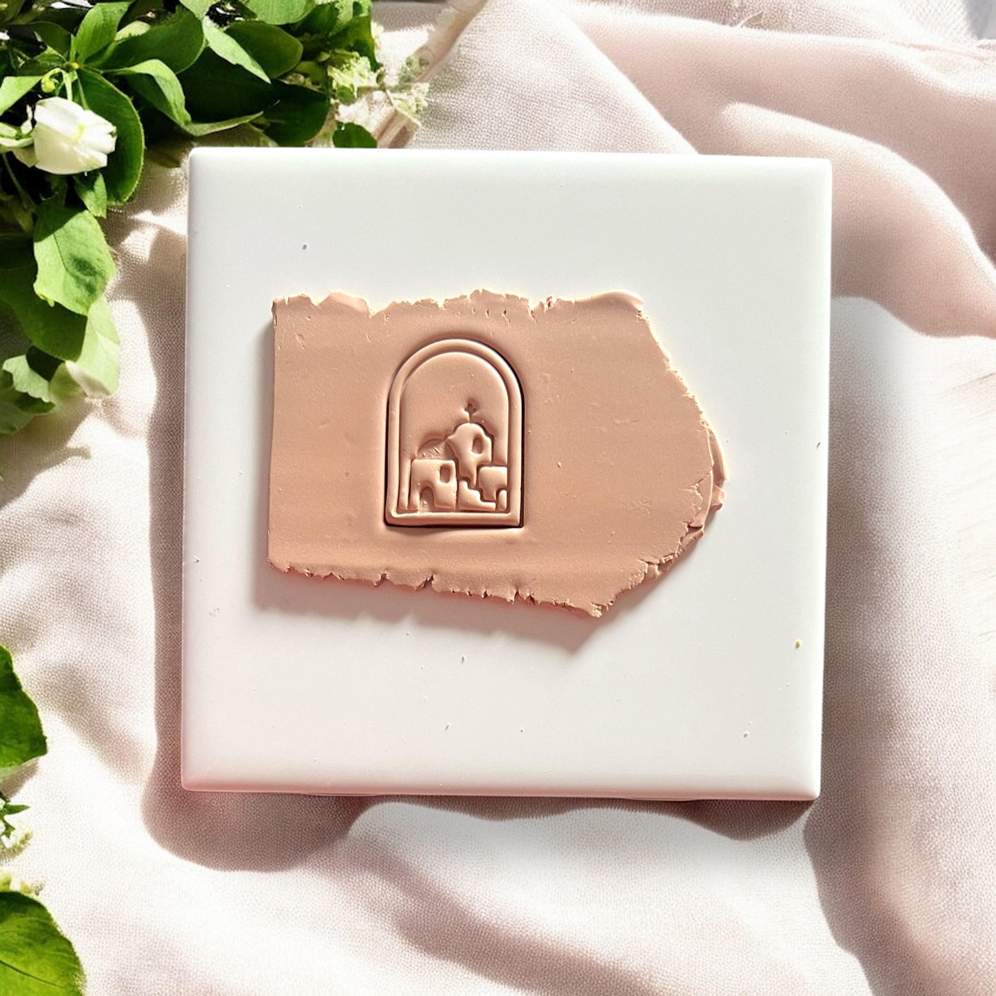 Uncut clay slab with arched Santorini village design impressed into light terracotta-colored clay.