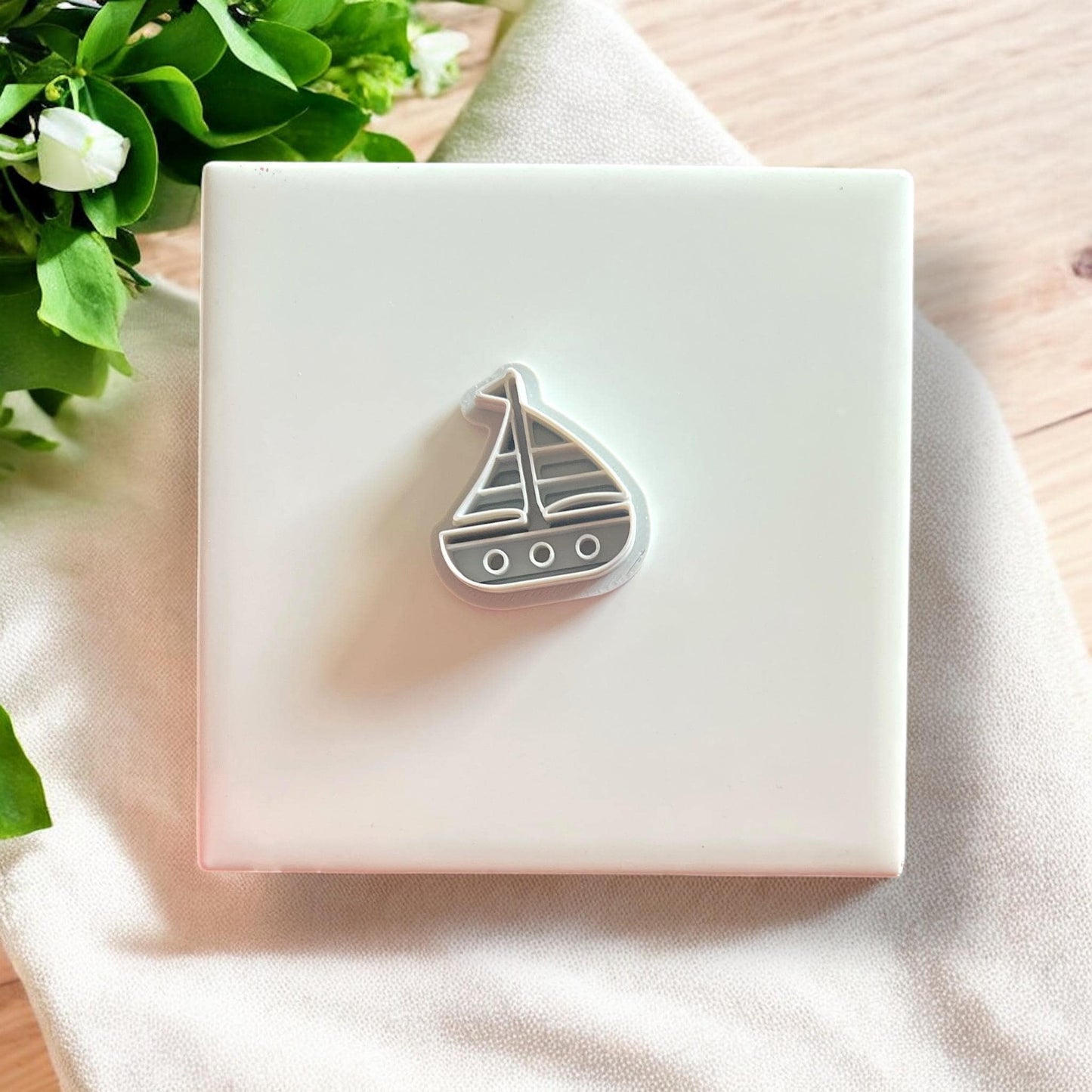 Close-up of the sailboat polymer clay mold with a lavender clay cutout, highlighting its sharp, clean edges.