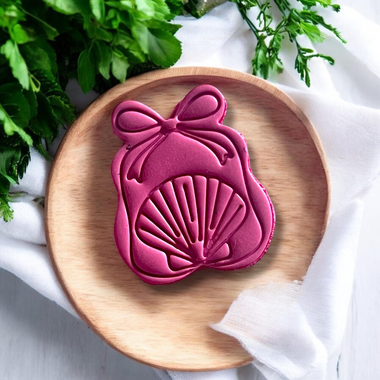 Coastal-inspired polymer clay design with shell and bow detailing, shaped using a clay cutter.