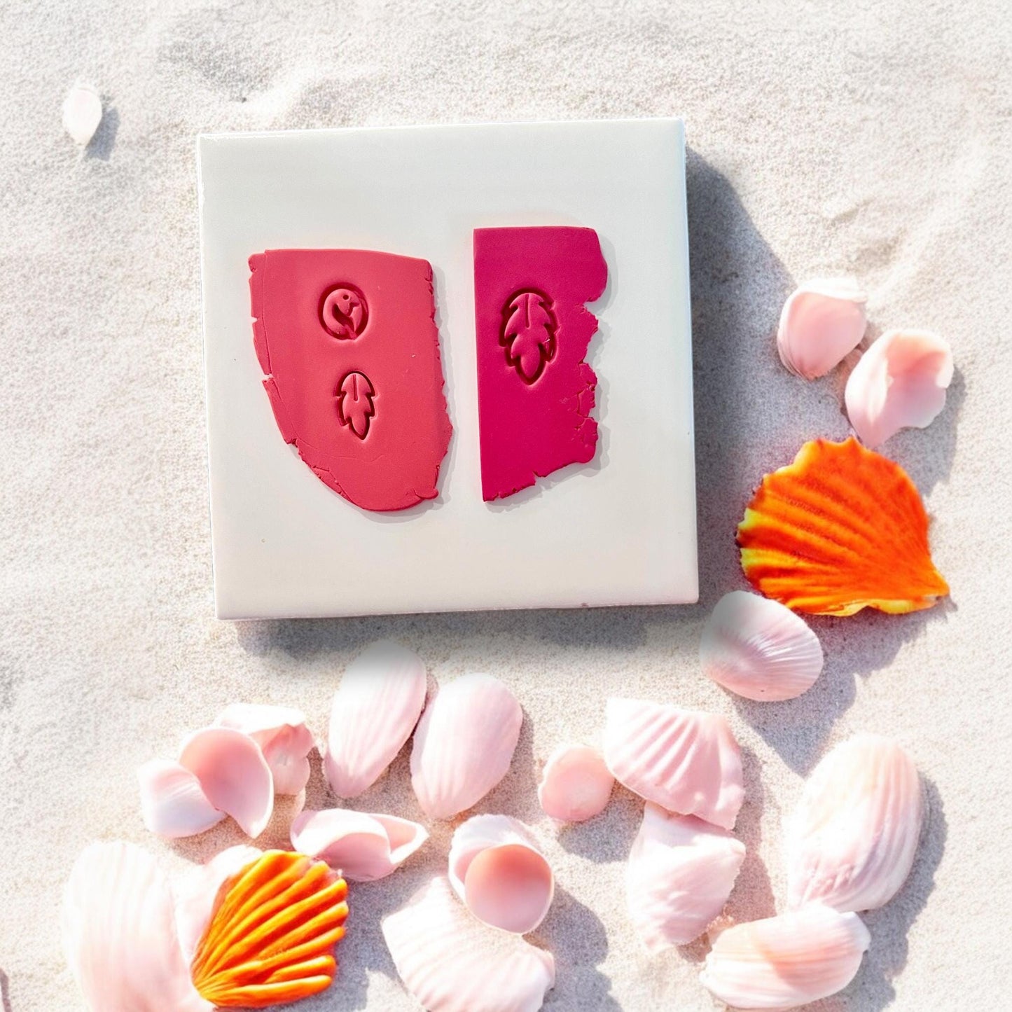 Three-part flamingo and feather clay imprints in pink clay on tile