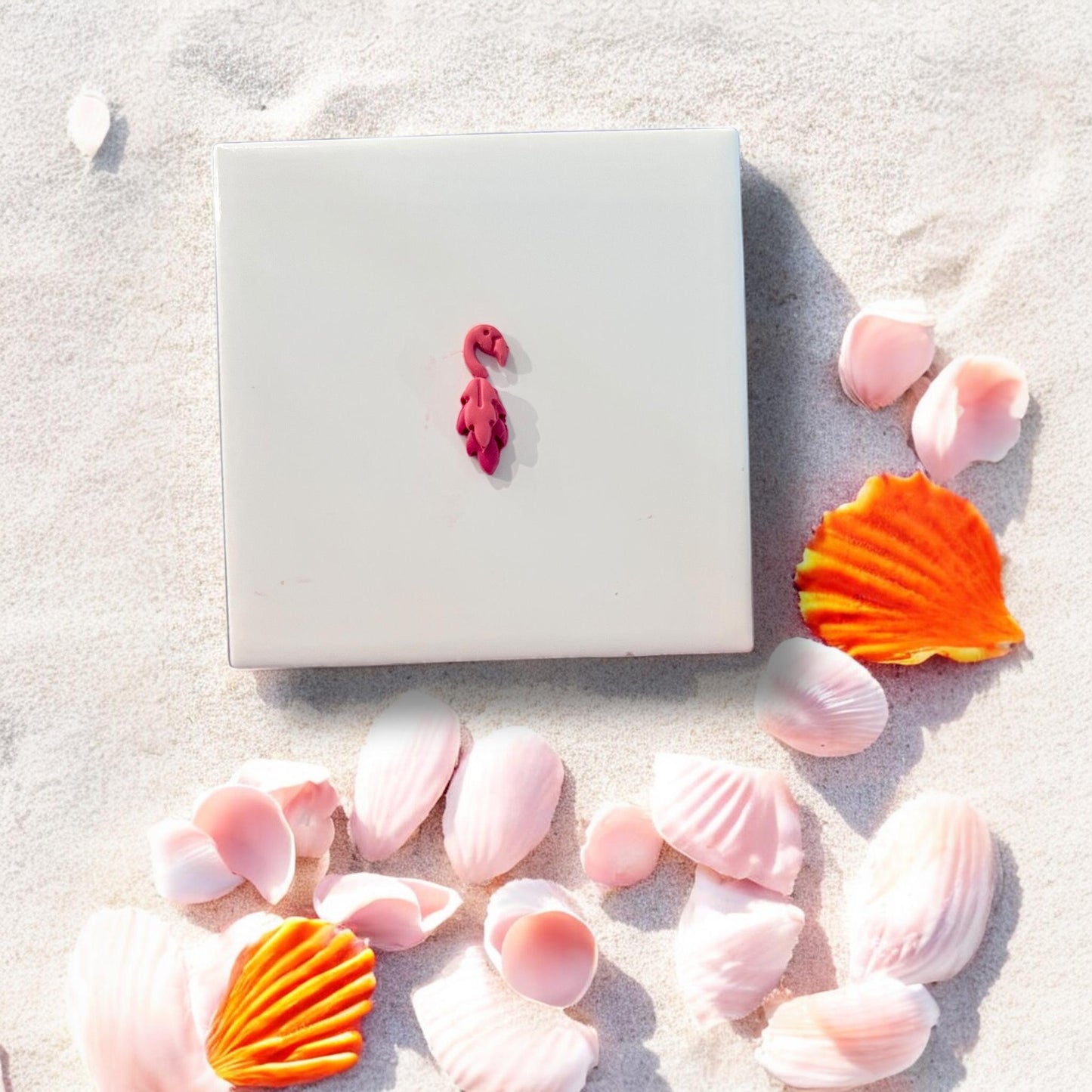 Assembled red flamingo clay cutout with feather tail on white background