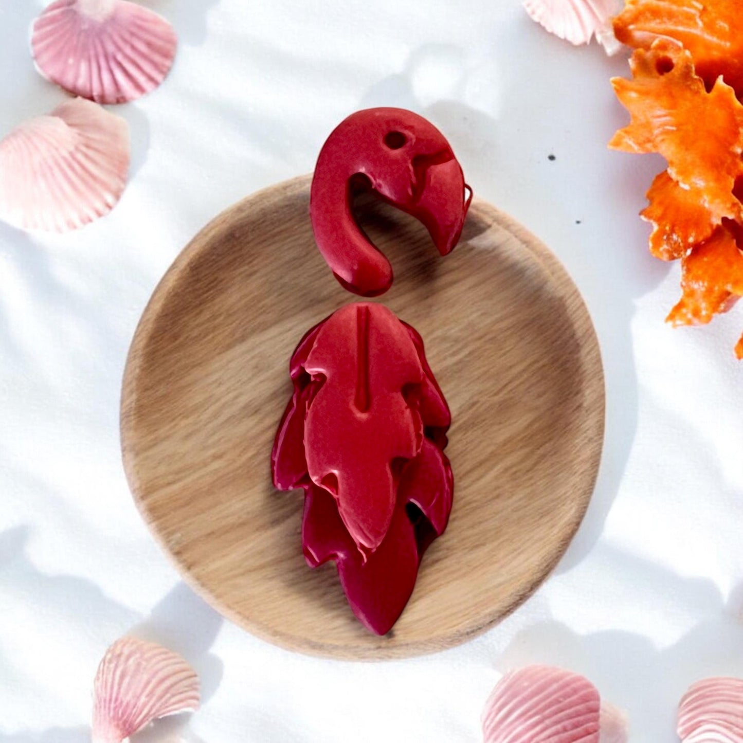 Completed red flamingo clay piece with detailed feathers on wood tray