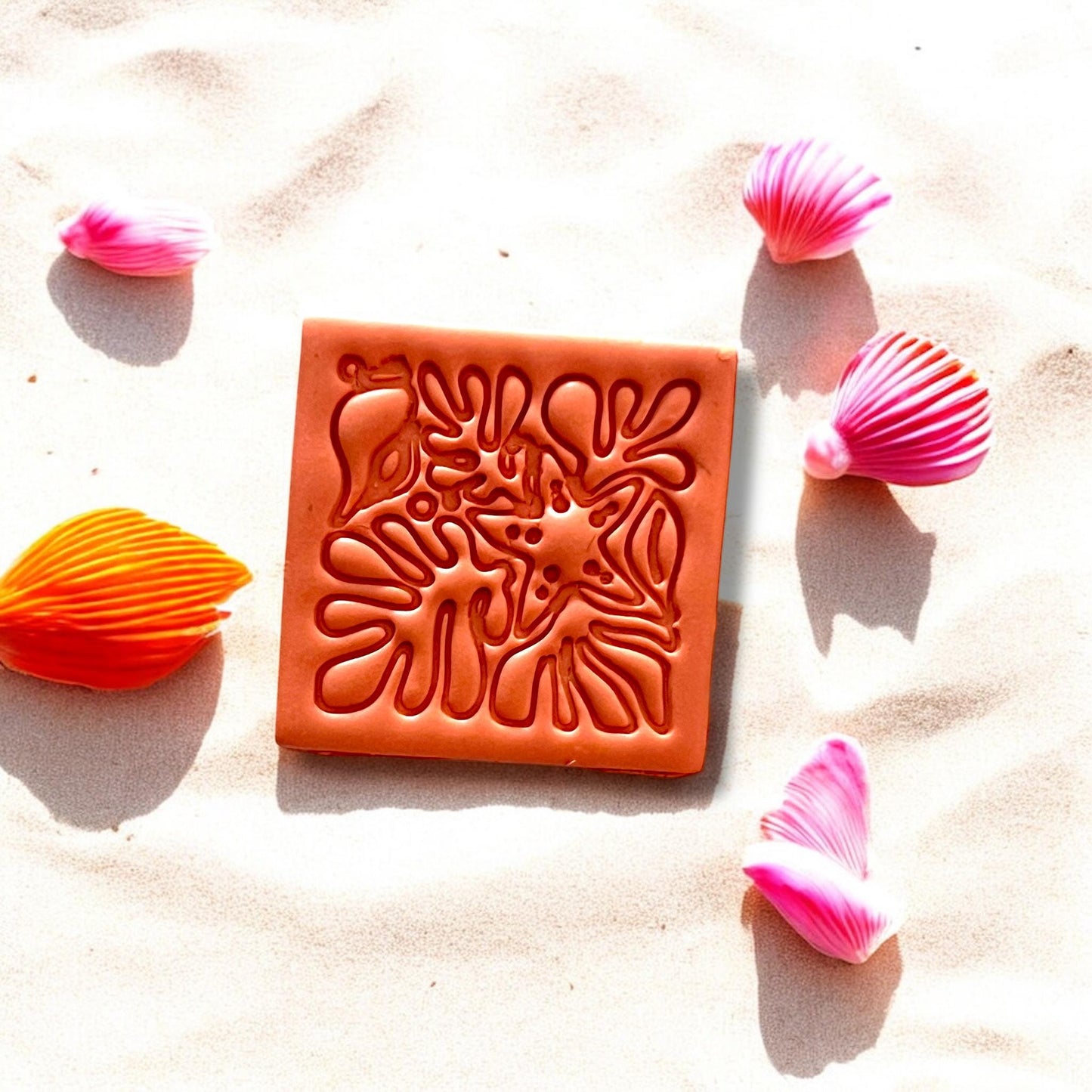 Close-up of starfish and coral beach motif slab on sand