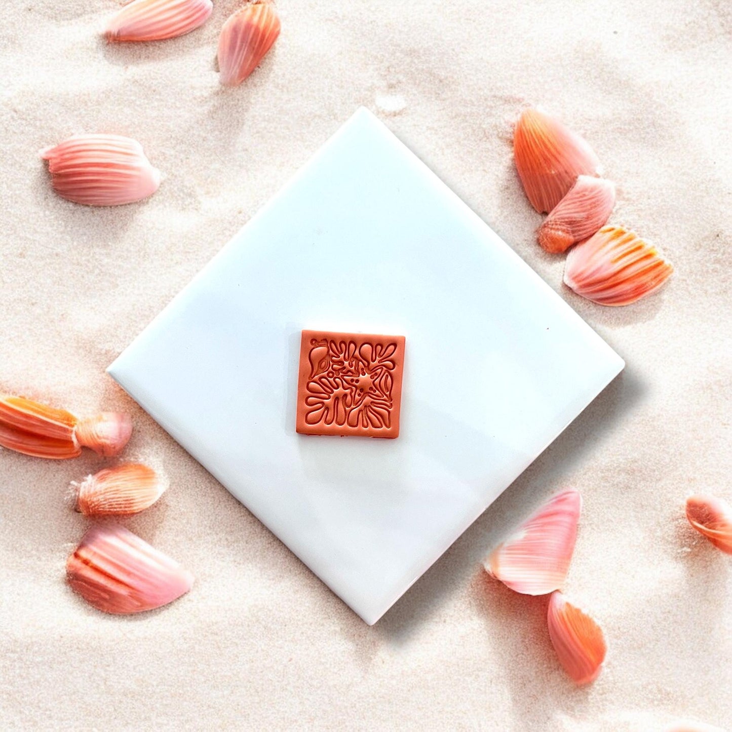 Finished square clay piece with beachy coral shell design