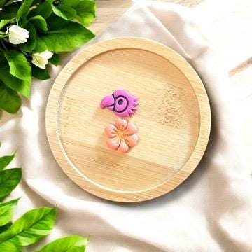 Tropical parrot and hibiscus polymer clay earrings on bamboo dish