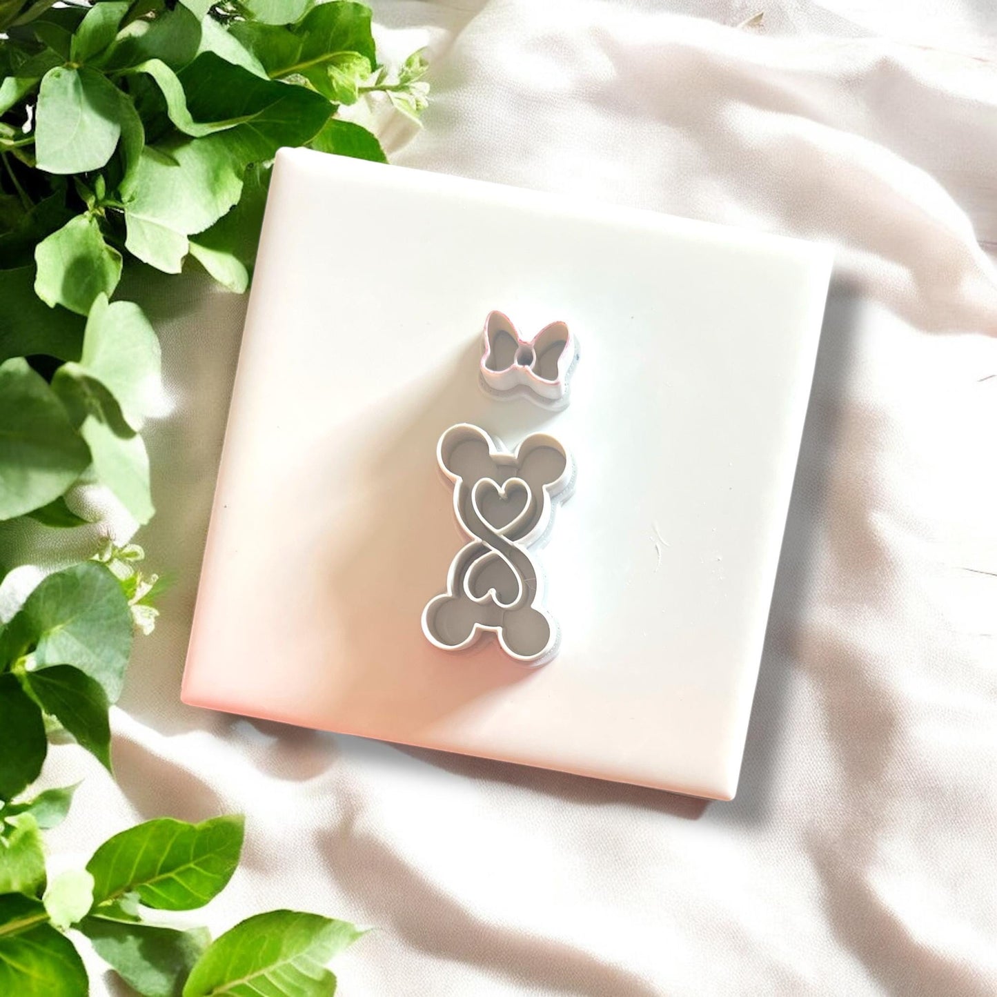 clay cutouts shaped like mouse ears and bow