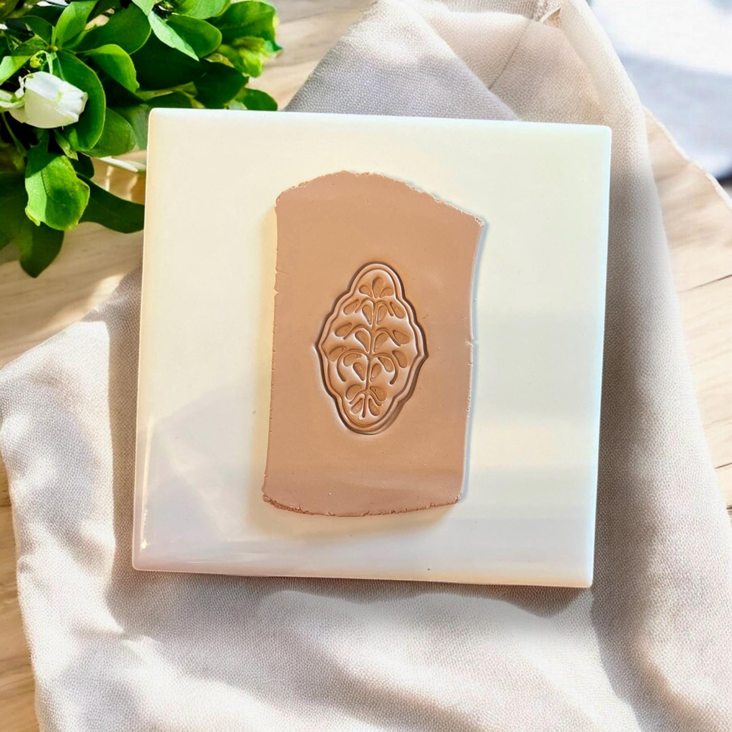 Brown clay slab with embossed Nordic flower earring design