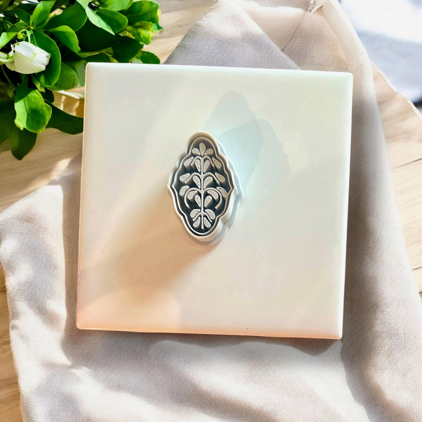 Top-down view of Scandinavian style floral cutter on tile background