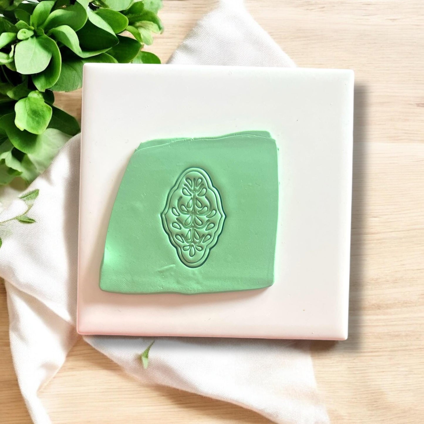 Green clay slab showing embossed Scandinavian floral cutter impression