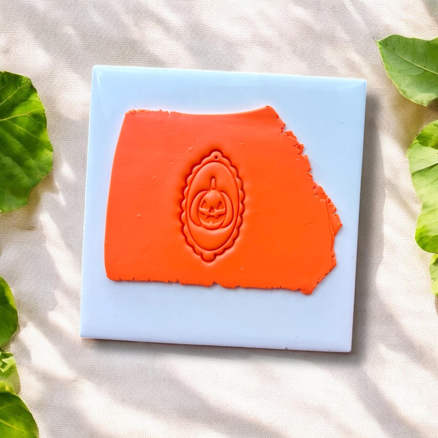 orange clay slab with oval pumpkin cameo impression