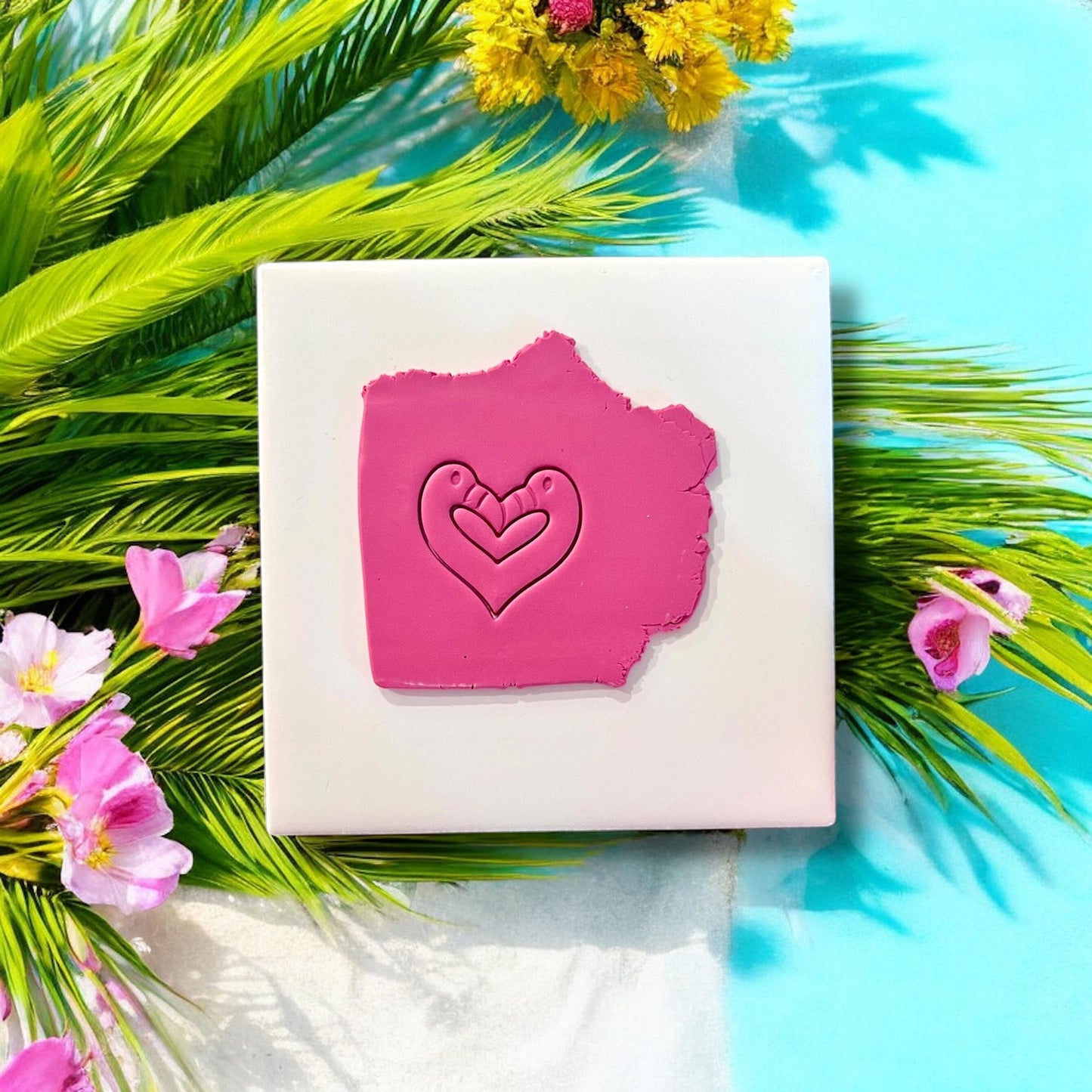 Flamingo heart clay imprint on pink polymer clay with tropical flowers