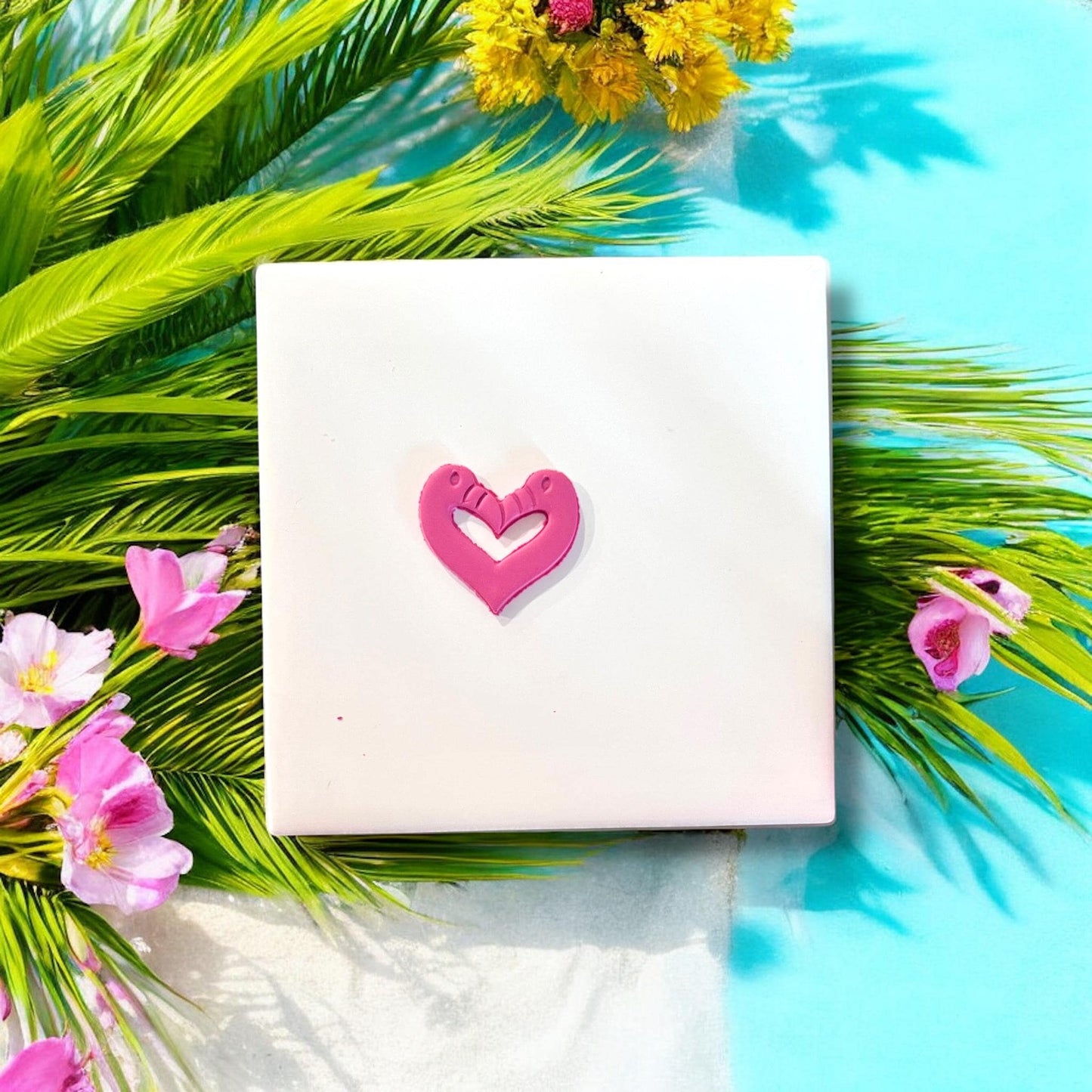 Finished pink flamingo heart clay cutout on white background