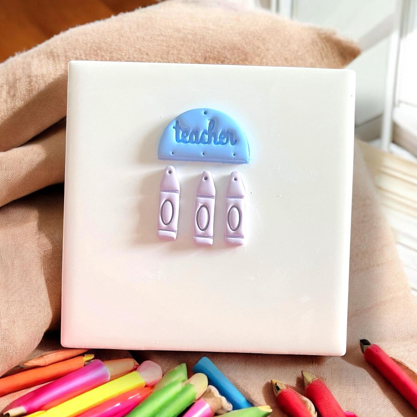 Finished earring components with blue “teacher” top and three crayons