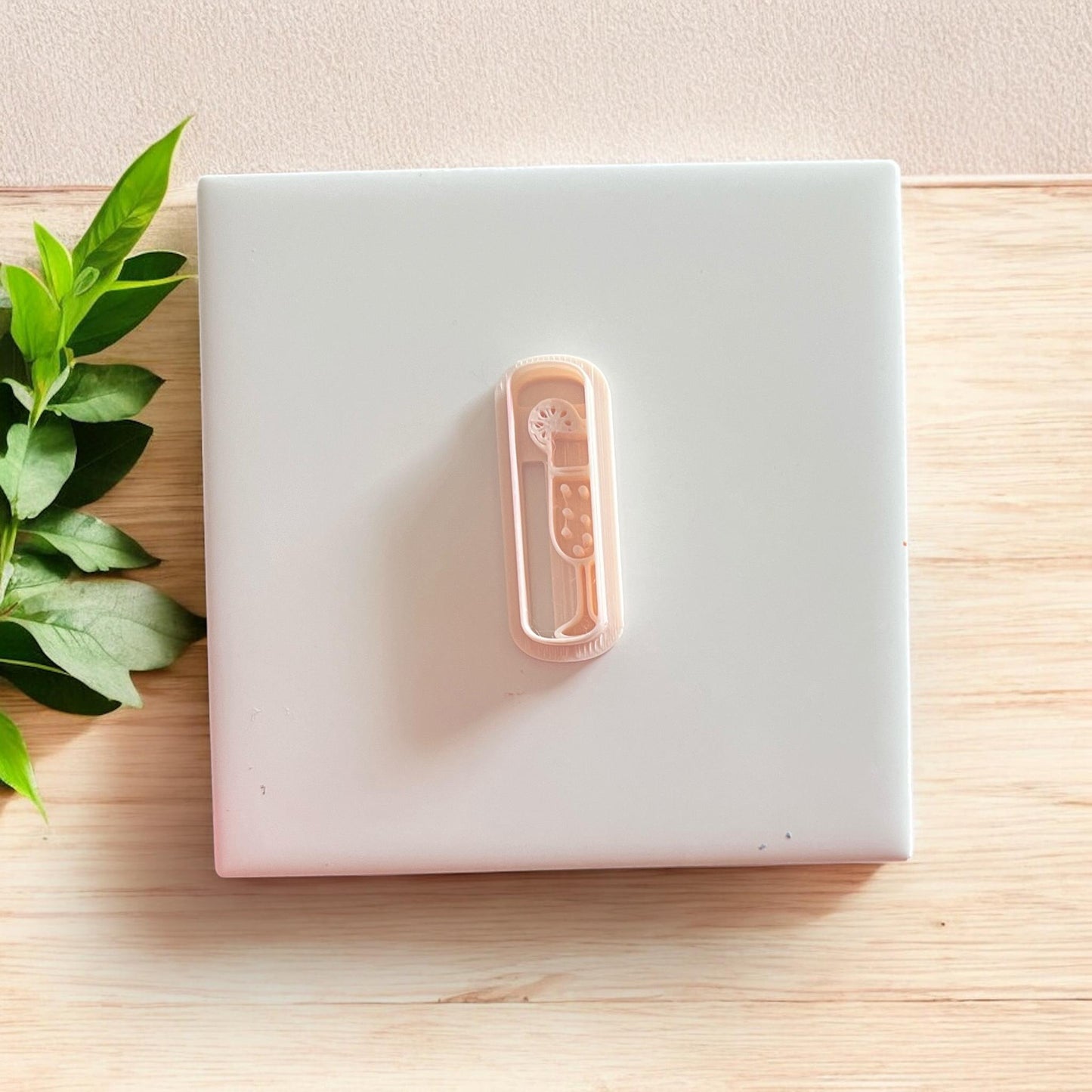 Top-down view of mimosa cutter and clay shape with leaf accents