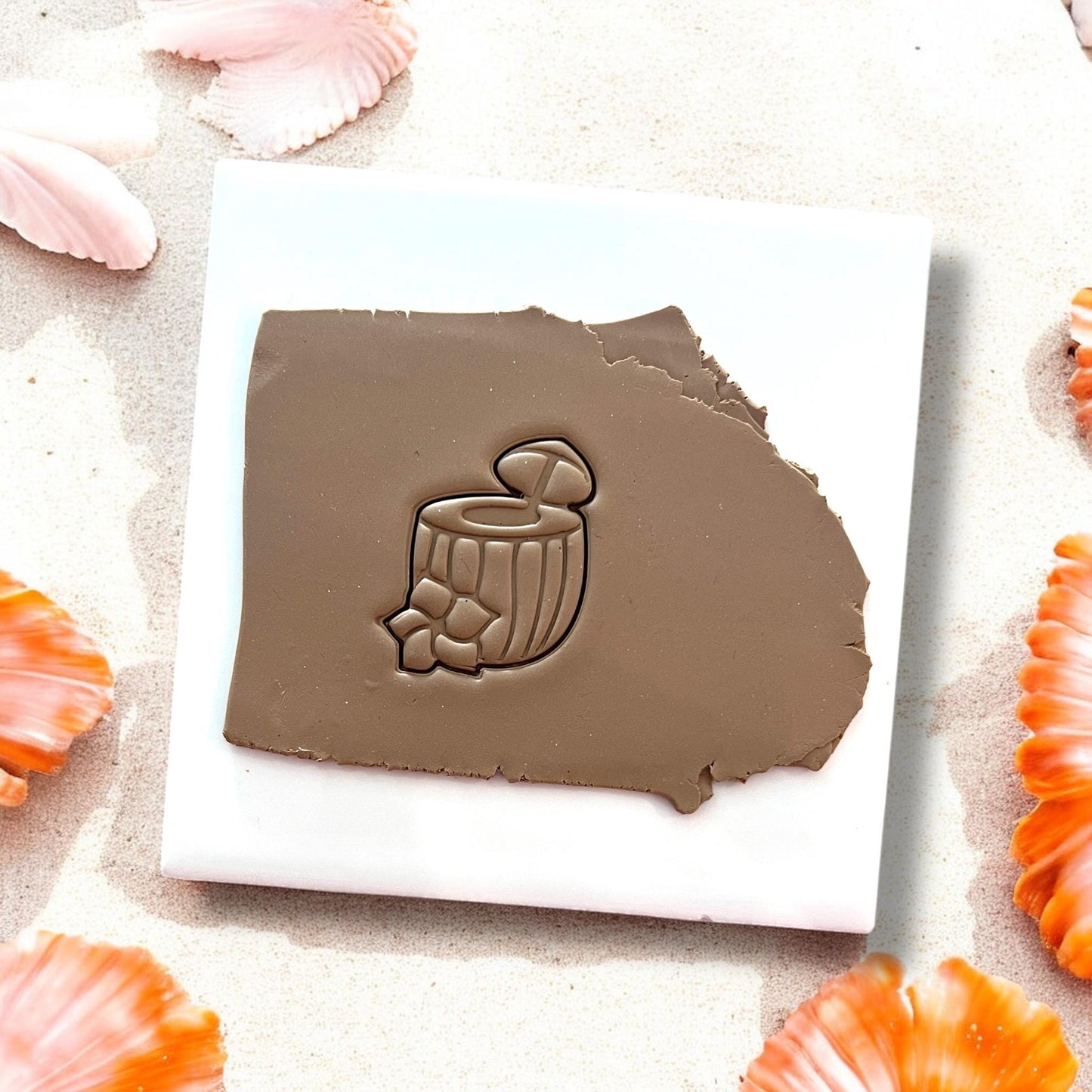 Brown clay slab with coconut cocktail shape pressed into it