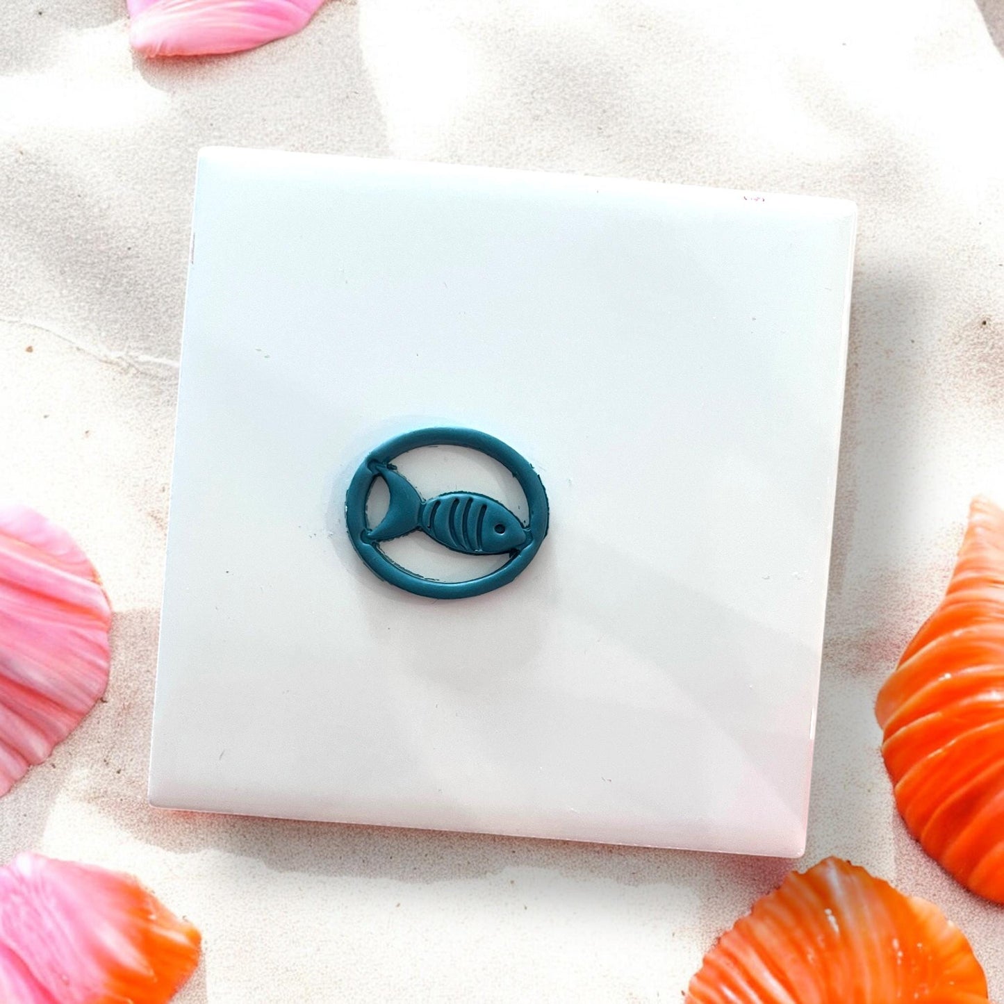 Finished round fish design in dark teal polymer clay
