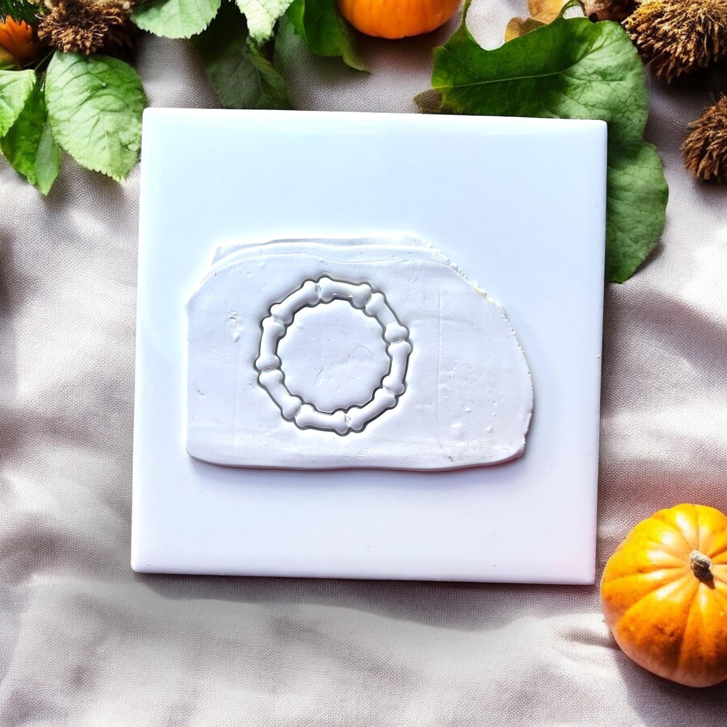 Bone wreath clay impression on white tile
