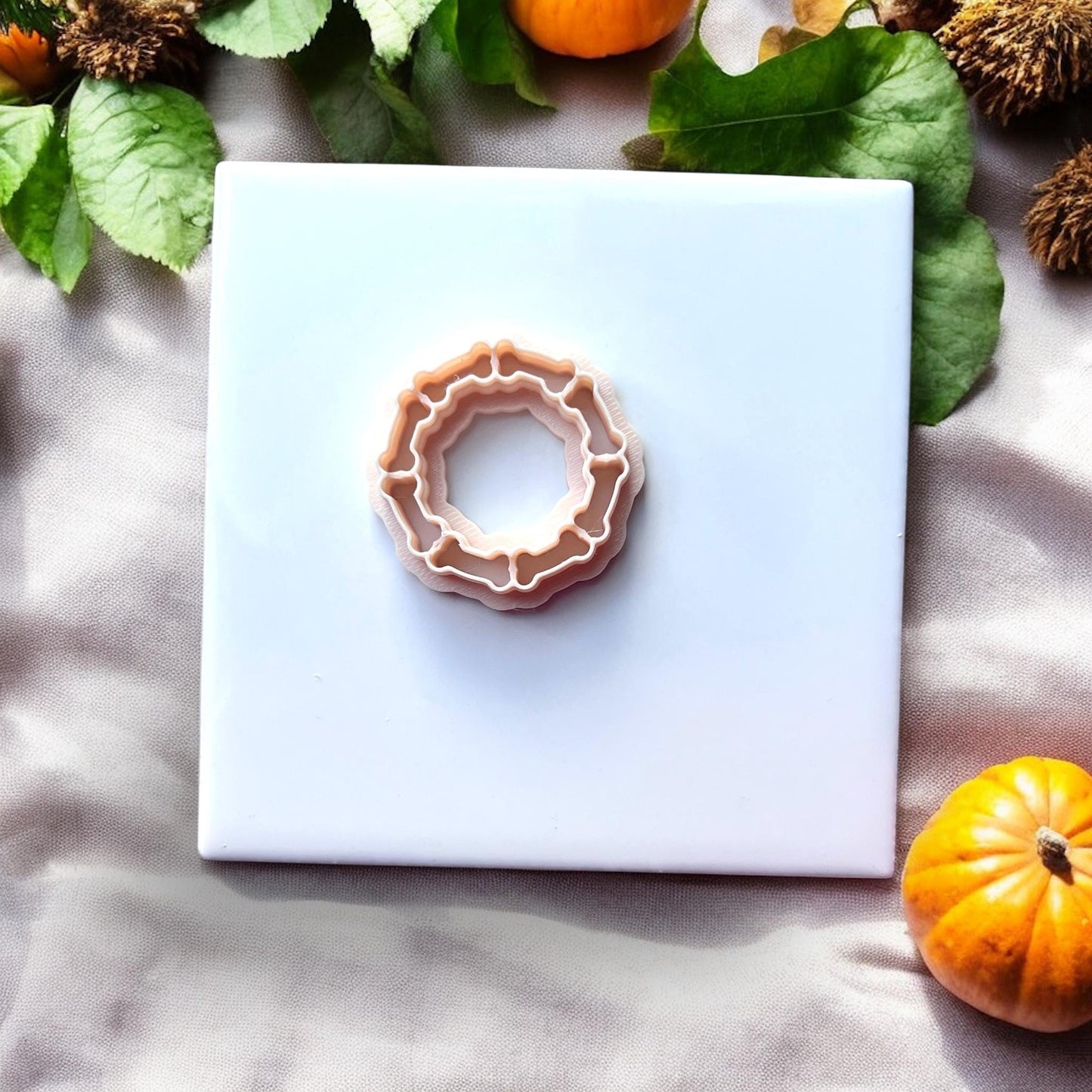 Top-down view of bone wreath clay cutter on white background