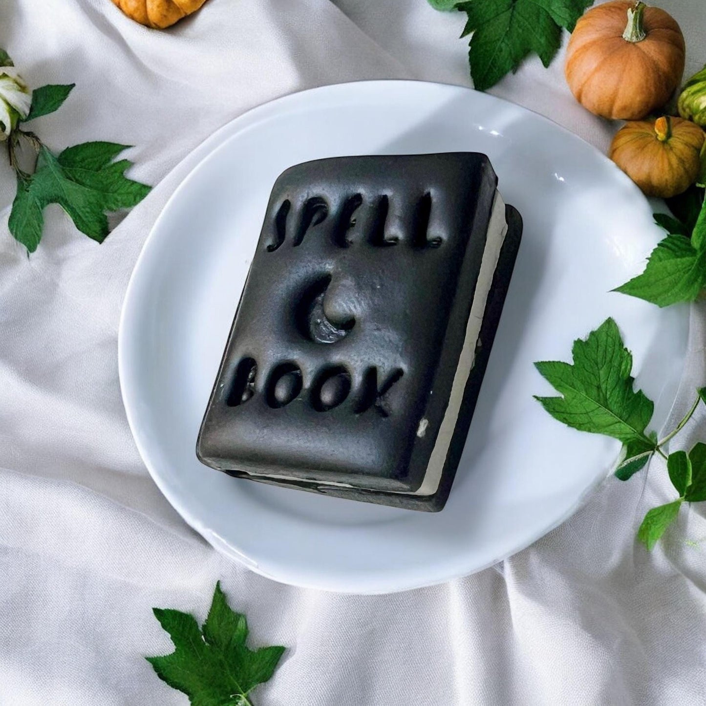 Black finished clay earring shaped like a spell book with “Spell Book” and moon detail