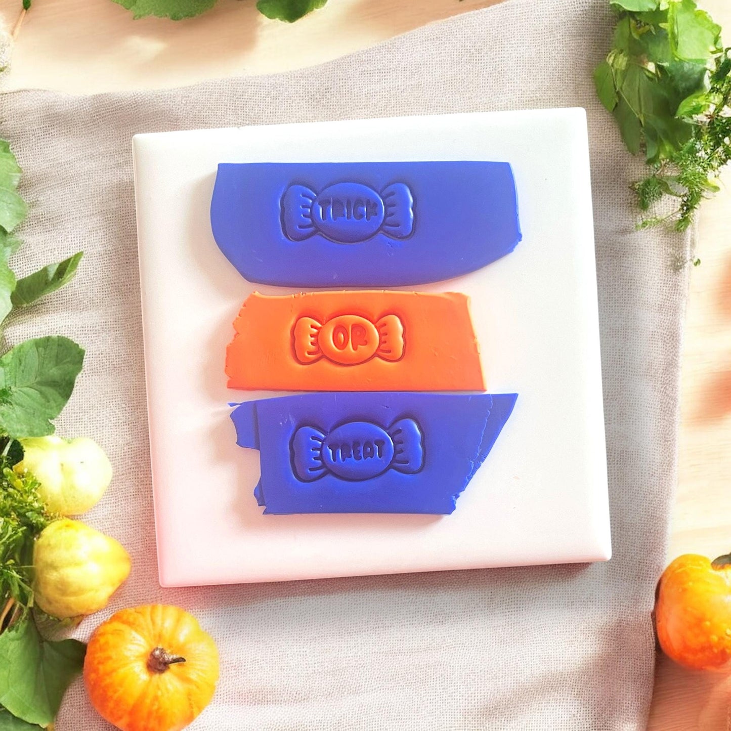 Trick or treat candy impressions in orange and blue clay slabs