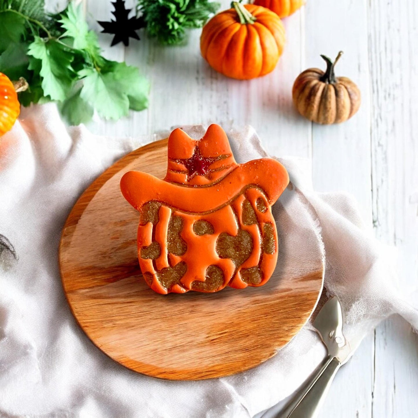 Clay imprint of cowprint pumpkin with star sheriff hat on square tile