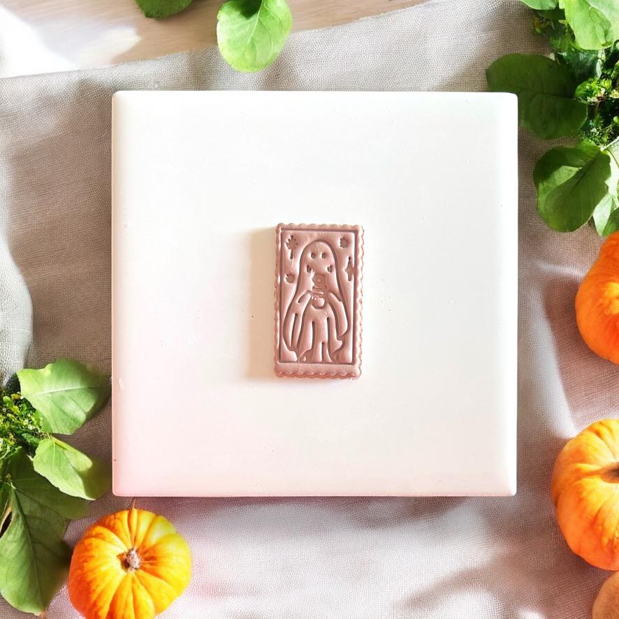 Halloween ghost cameo polymer clay cutter styled on white ceramic tile with greenery