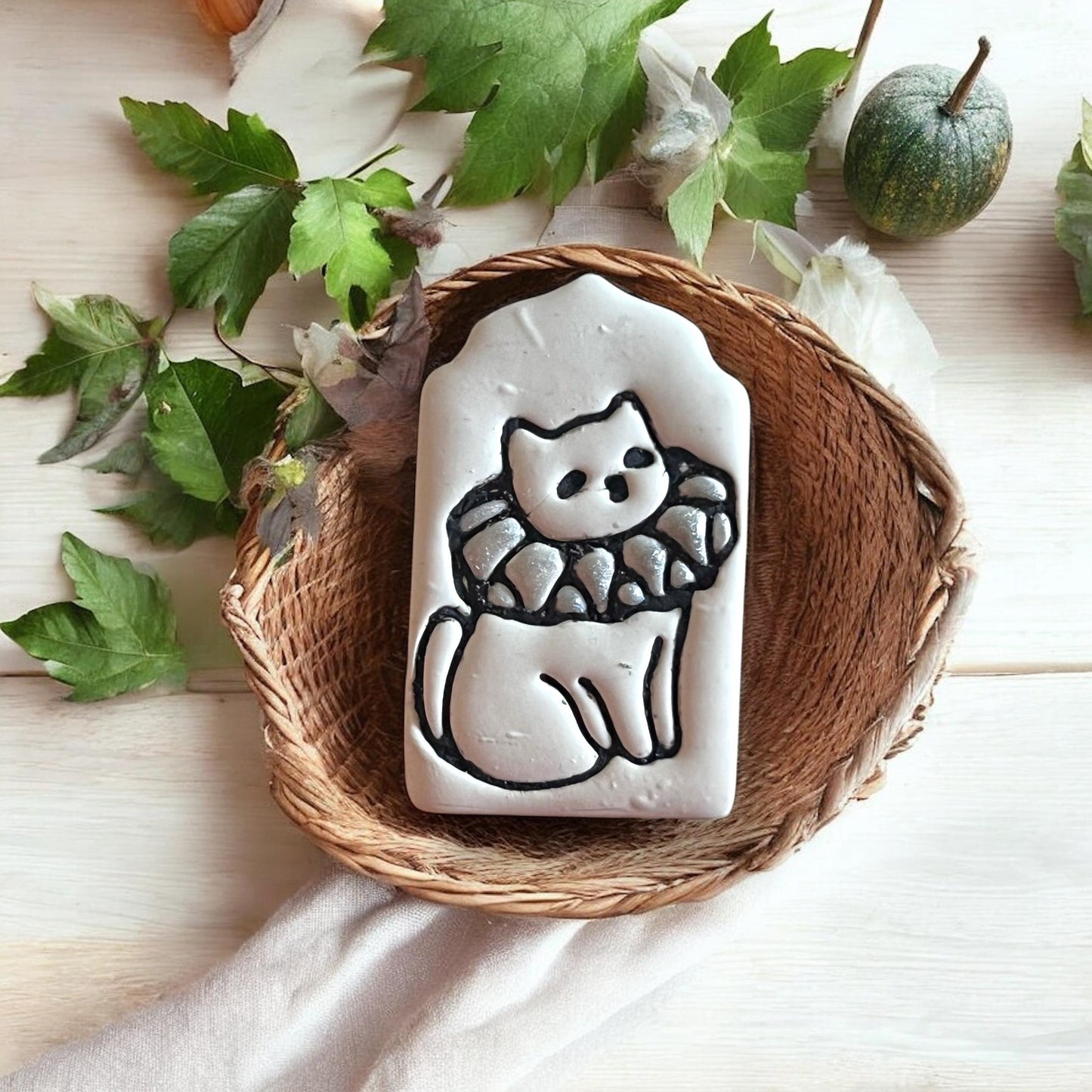 Full clay slab showing deep imprint of costumed cat with pointed tag frame