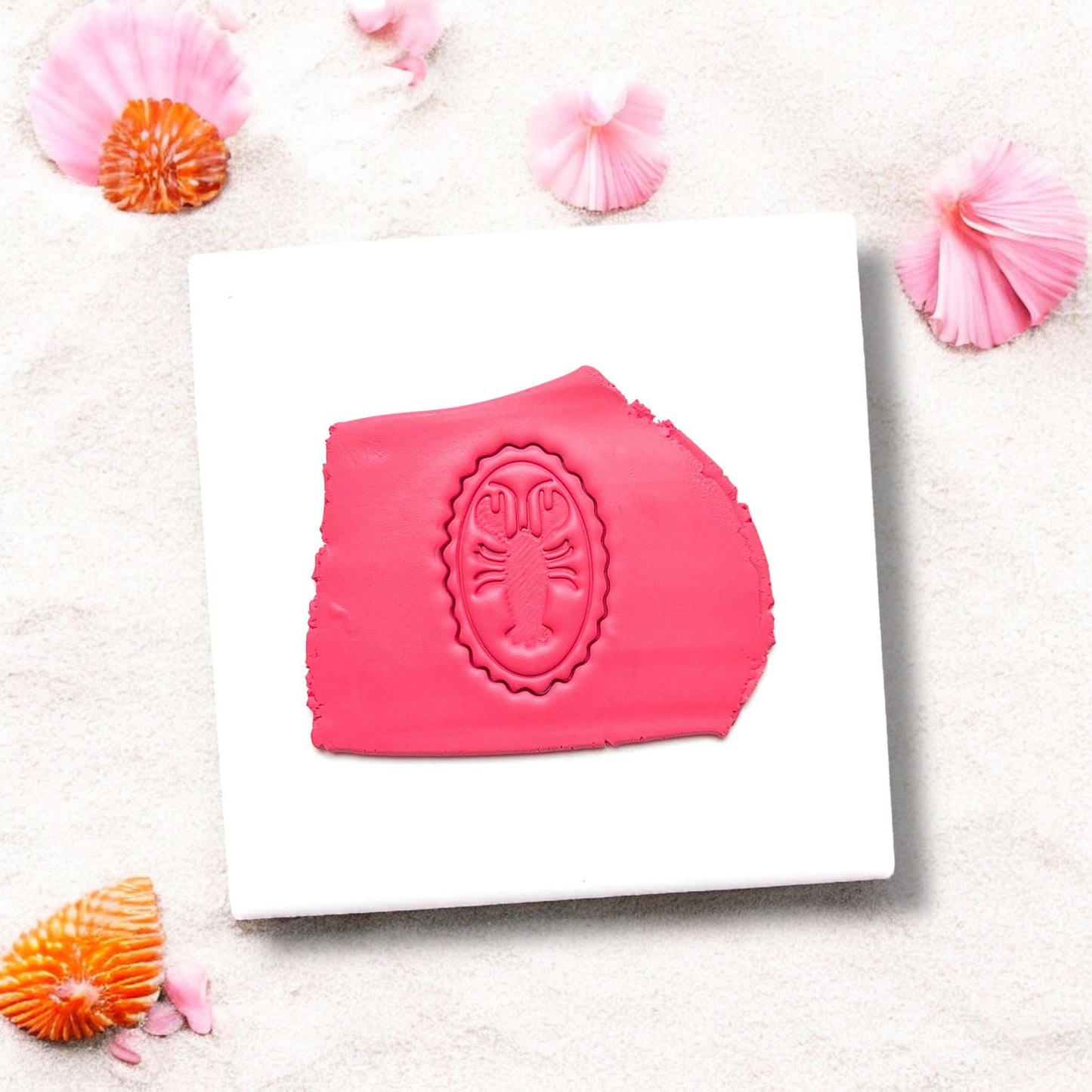 Bright pink clay slab with lobster cameo cutter impression
