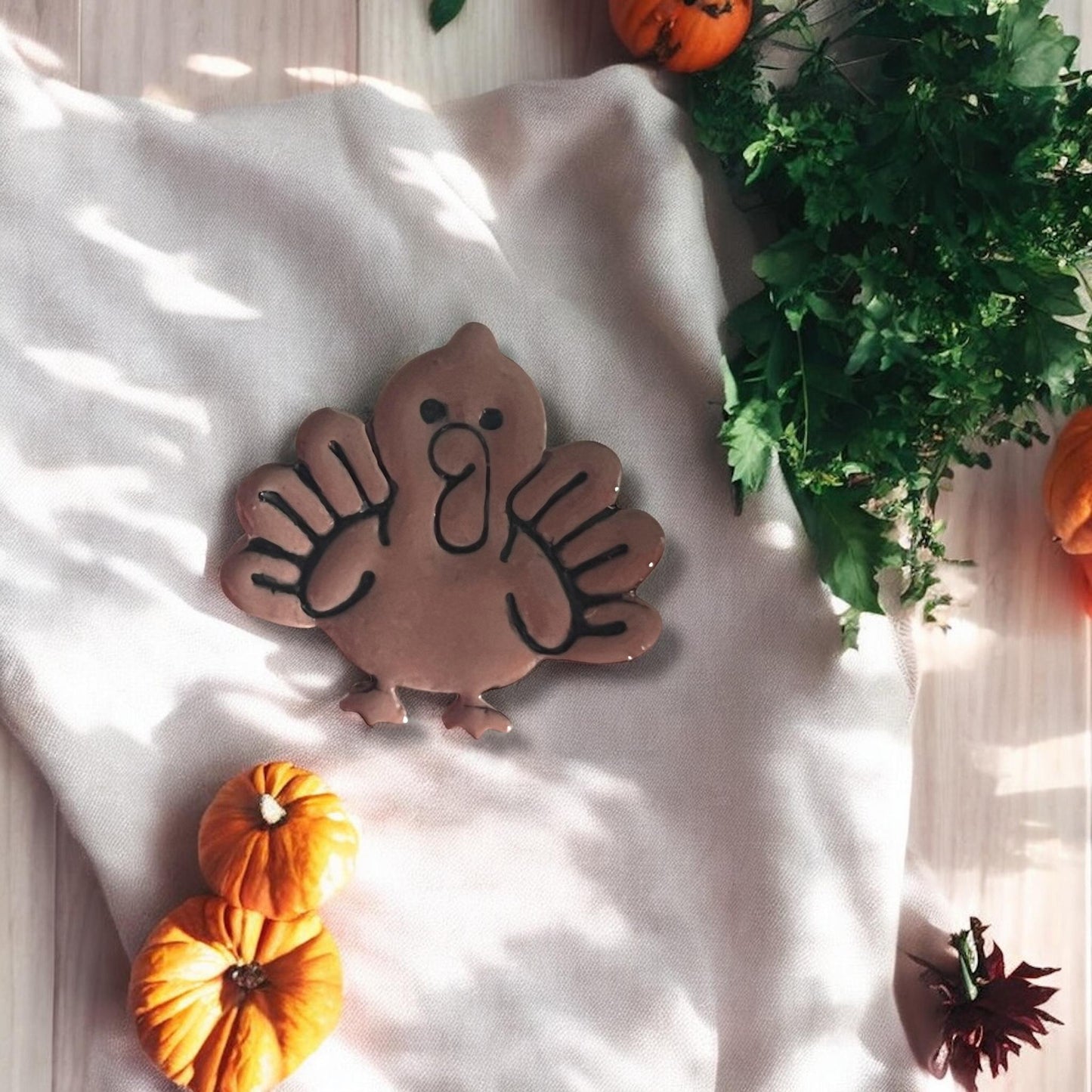 close-up of carved turkey earring clay piece