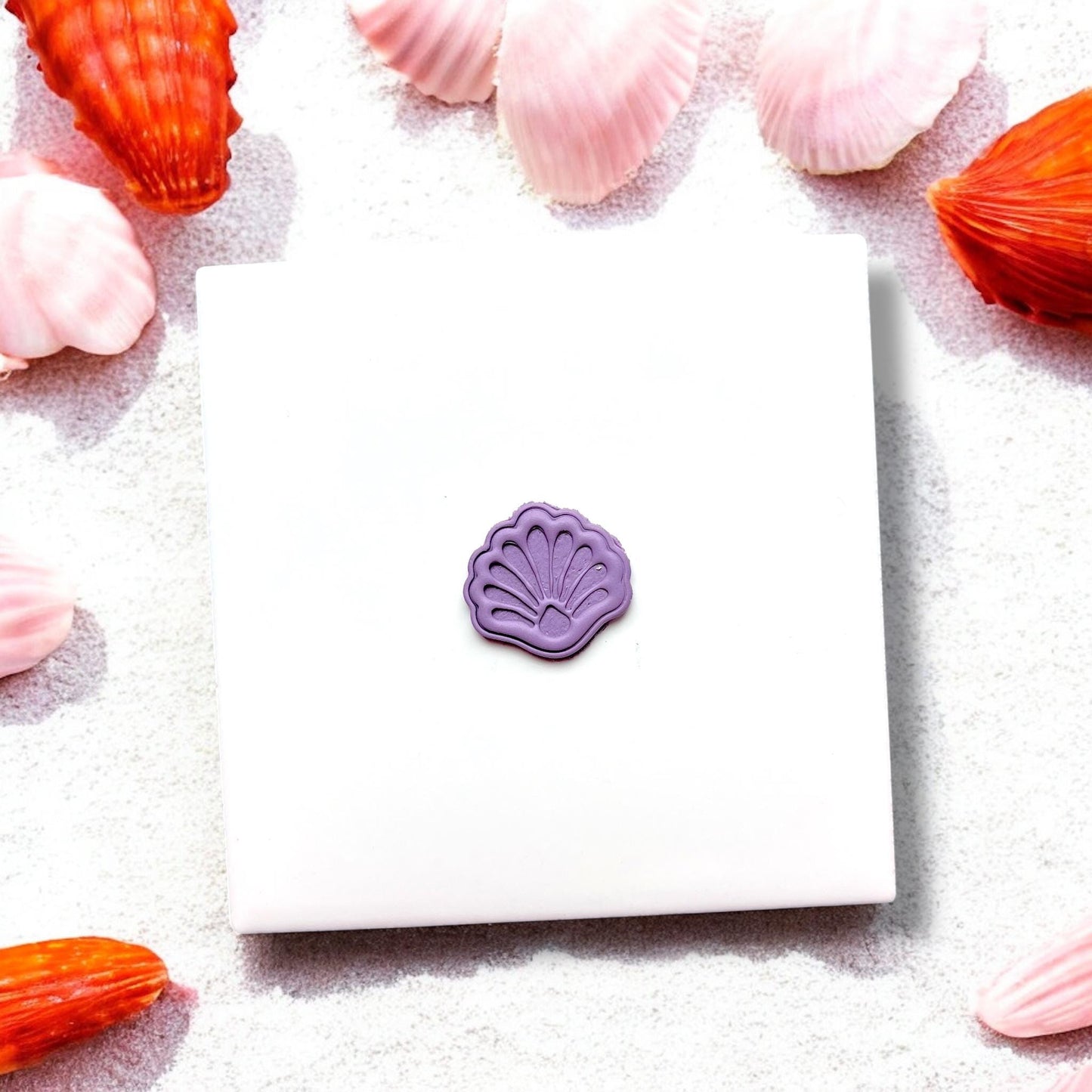 Small purple shell-shaped clay piece