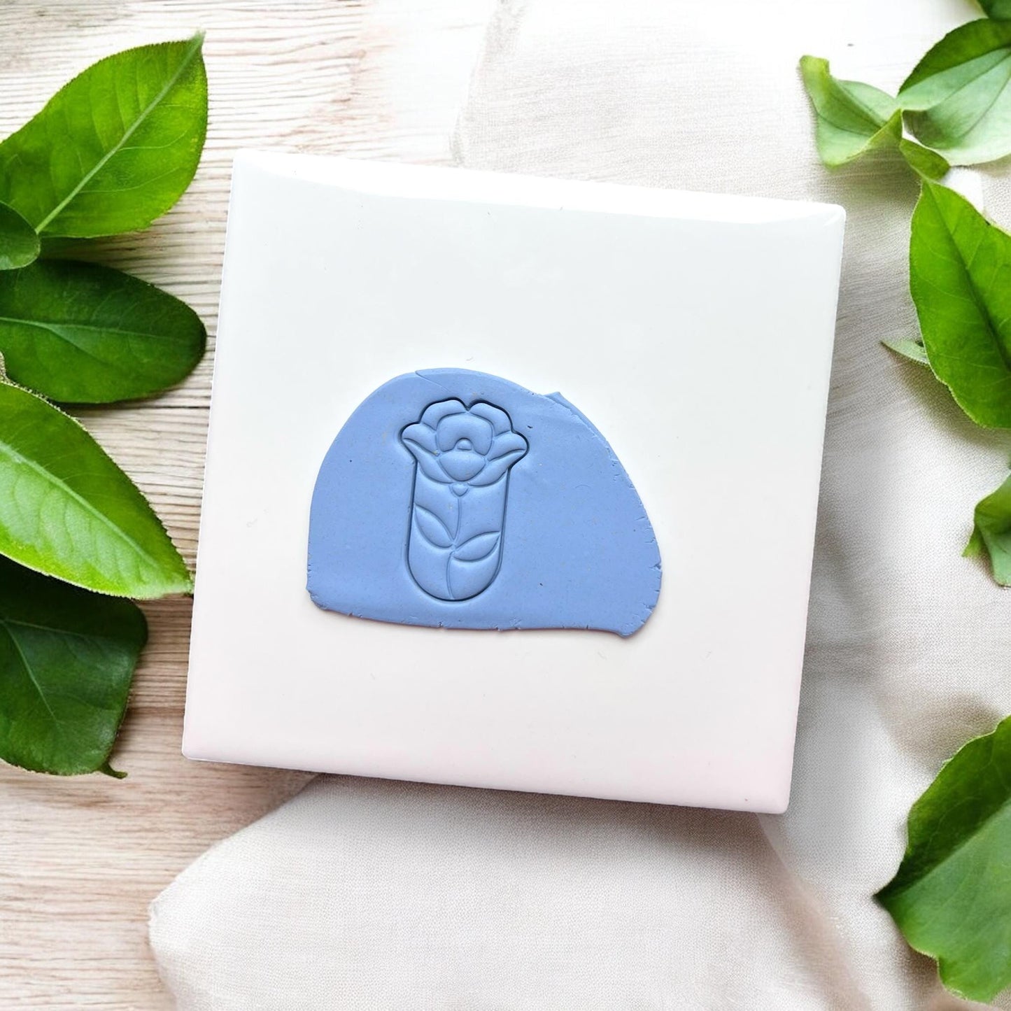 Light blue clay slab stamped with teardrop flower design