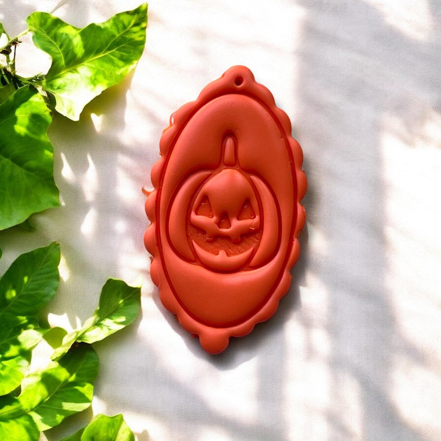 finished orange clay charm with scalloped frame