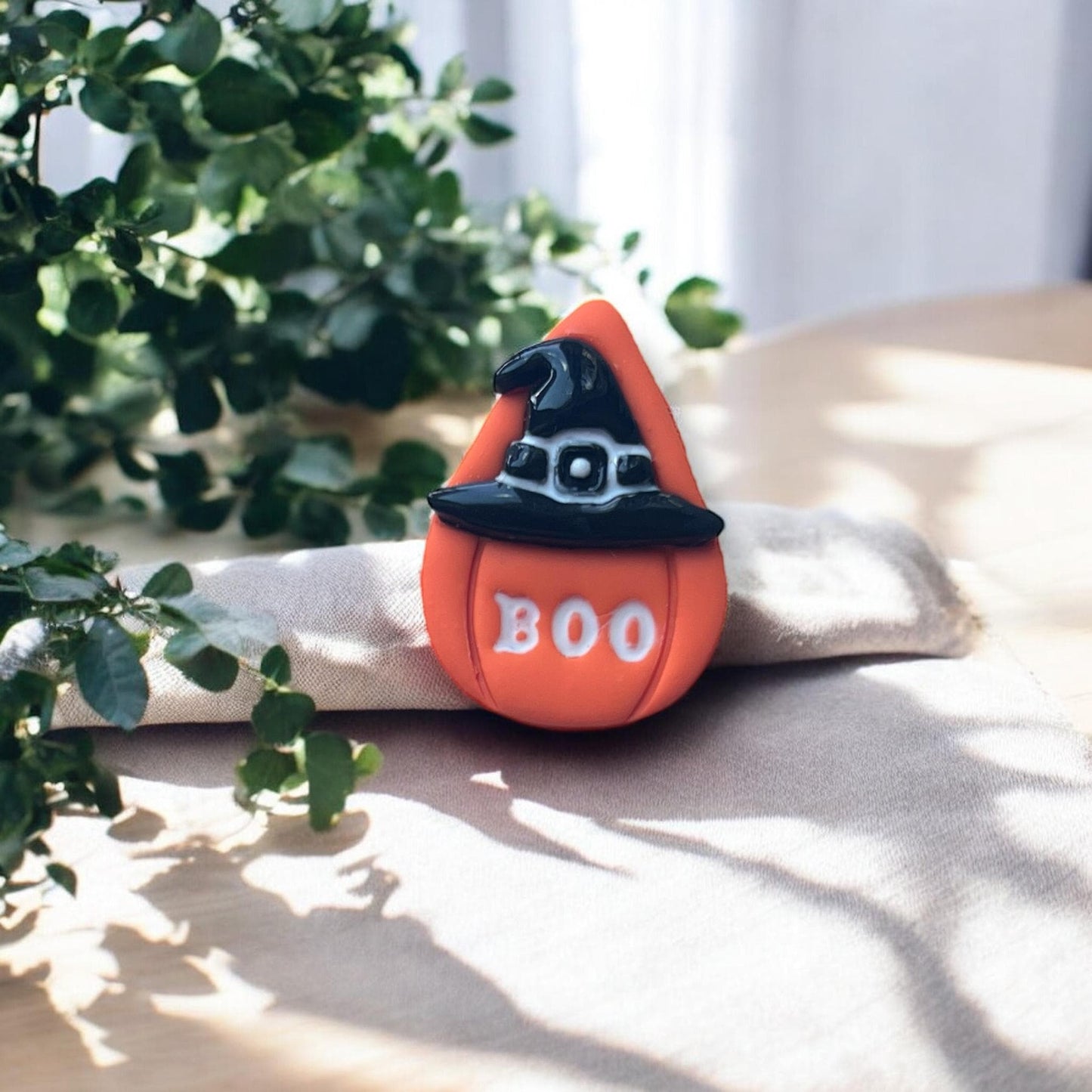 Finished boo pumpkin clay earring on fabric