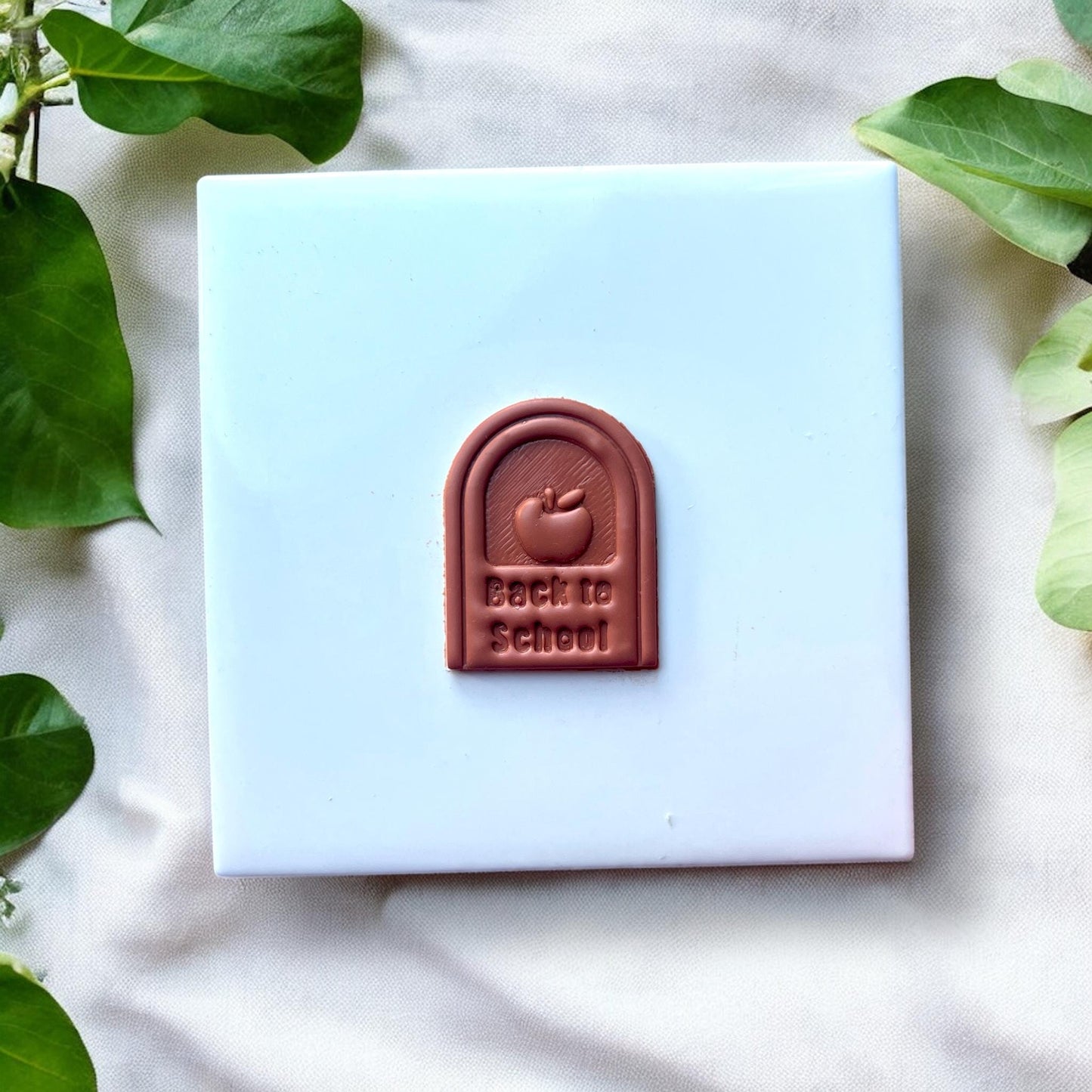 Cut and baked clay showing “Back to School” text and apple shape