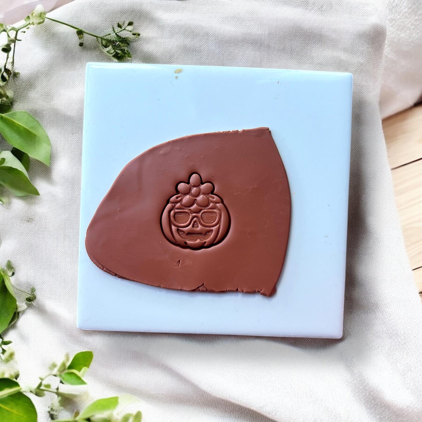 pumpkin character clay imprint on brown clay slab