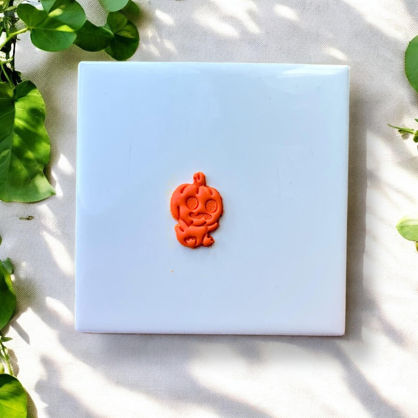 Close-up of orange clay pumpkin baby impression