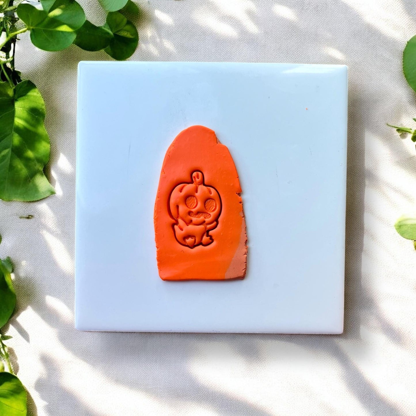Clay slab with pumpkin baby face stamped