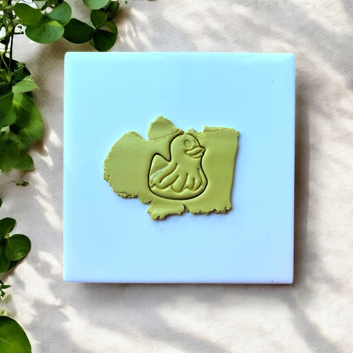 Duck floatie clay impression on green polymer clay