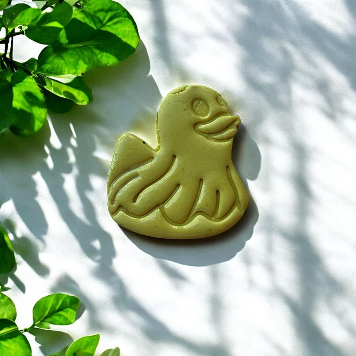 Finished duck floatie clay piece with leafy background